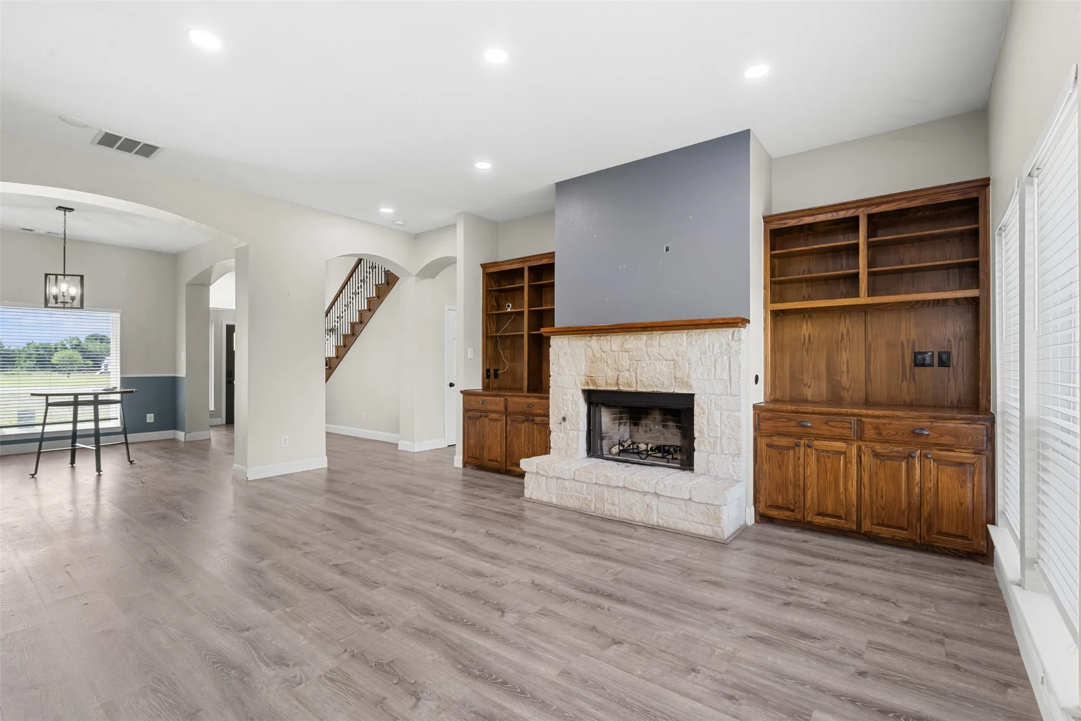 Spacious living area featuring light wood-finish flooring and recessed lighting