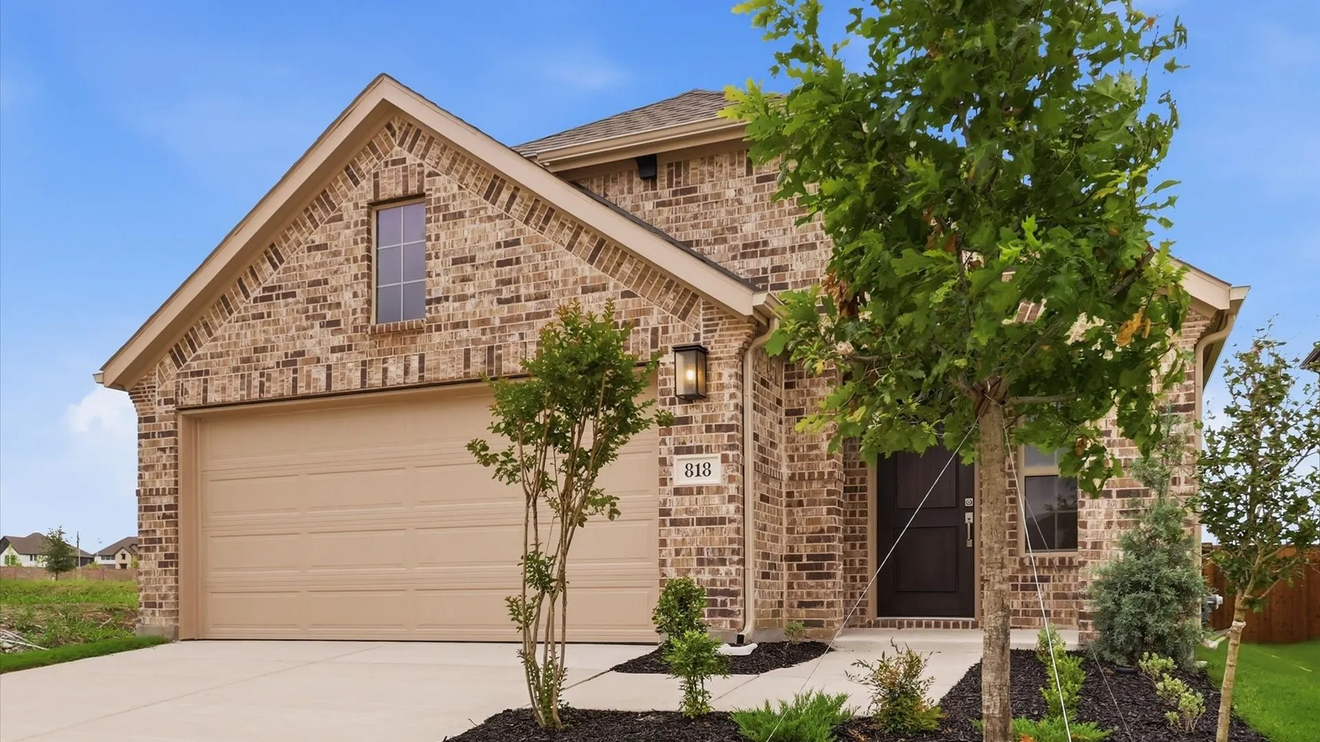 Brick veneer exterior with a gabled roofline, an attached two-car garage, and a covered front entry