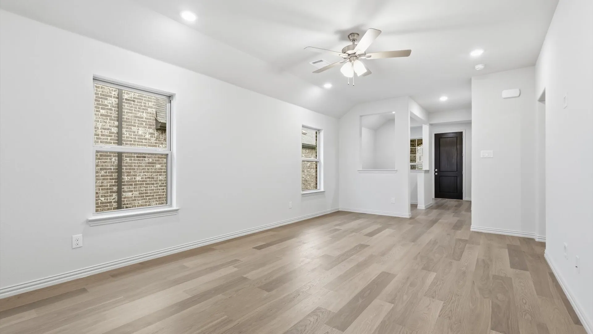 Spacious interior featuring wood-finish flooring, recessed lighting, and a ceiling fan