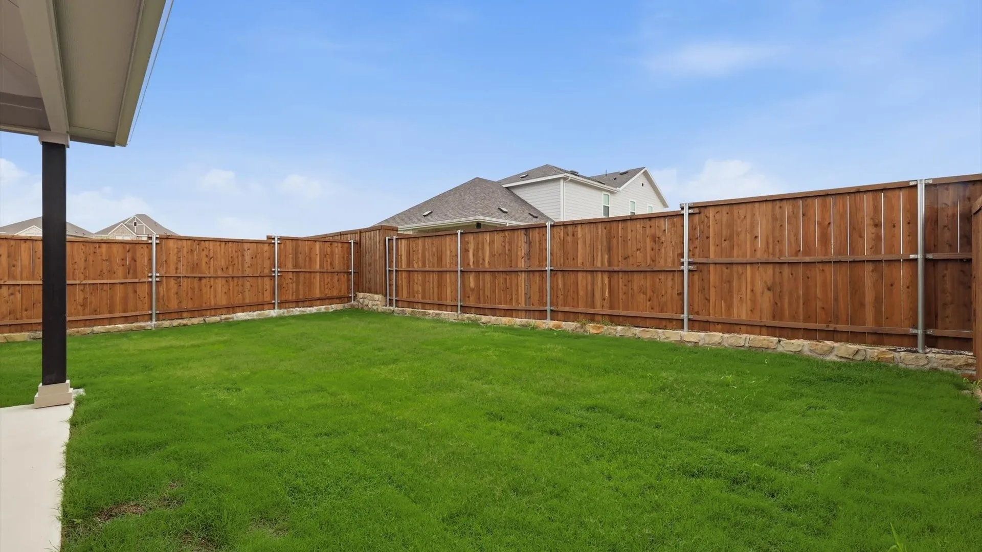 Expansive grass lawn with a full wood privacy fence