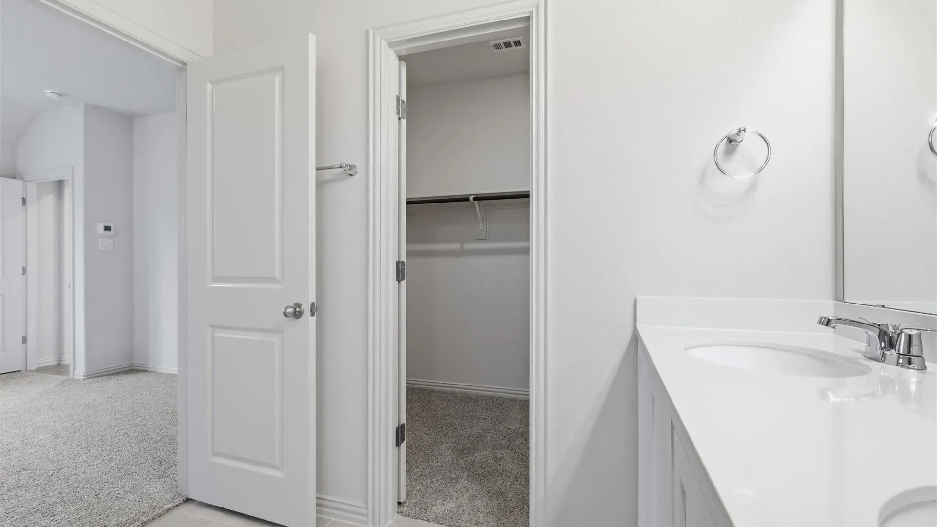 Bathroom vanity with a single basin sink, chrome faucet, and expansive countertop