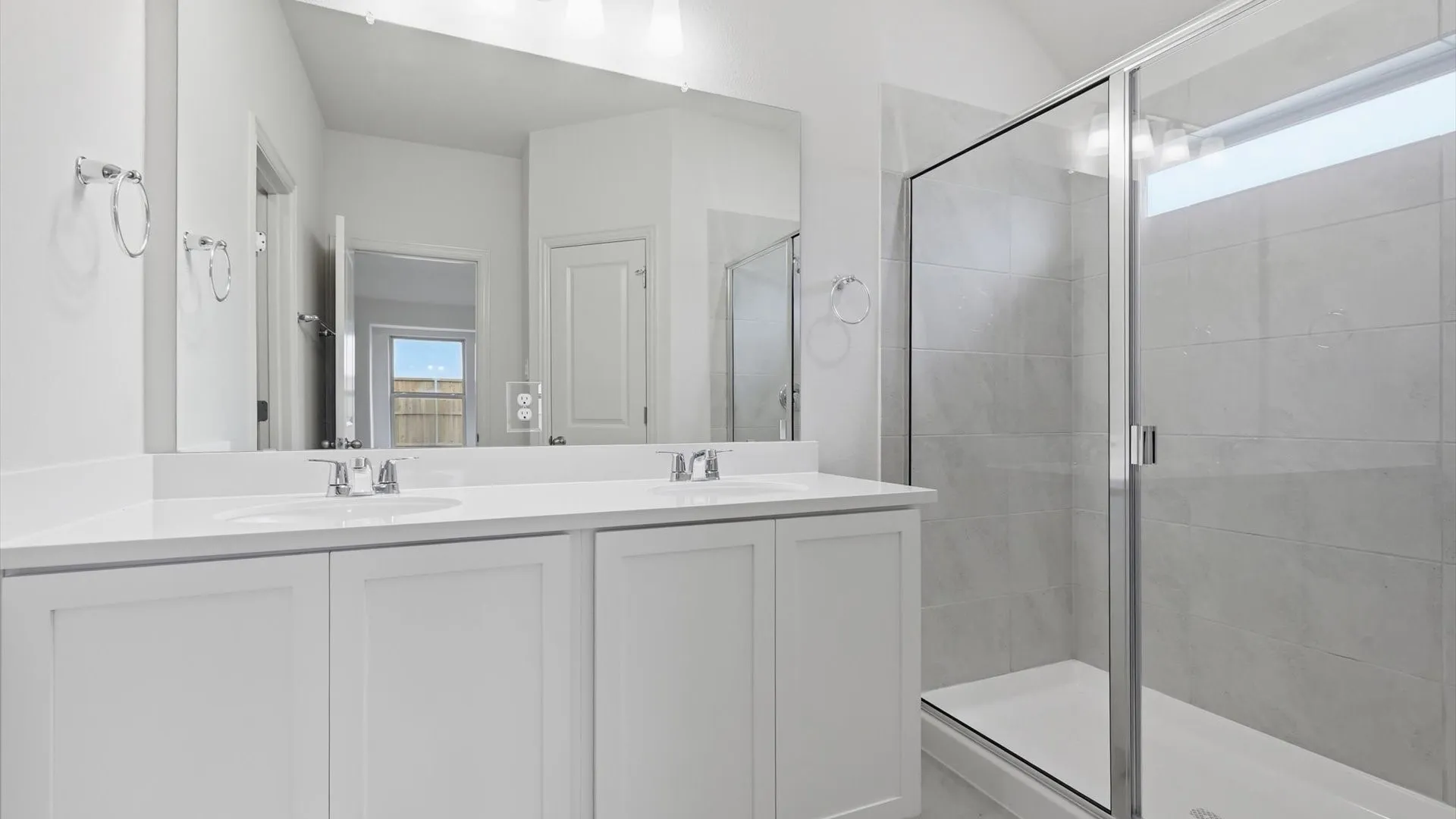 Bathroom featuring a dual vanity with white cabinetry, white countertop, and chrome fixtures
