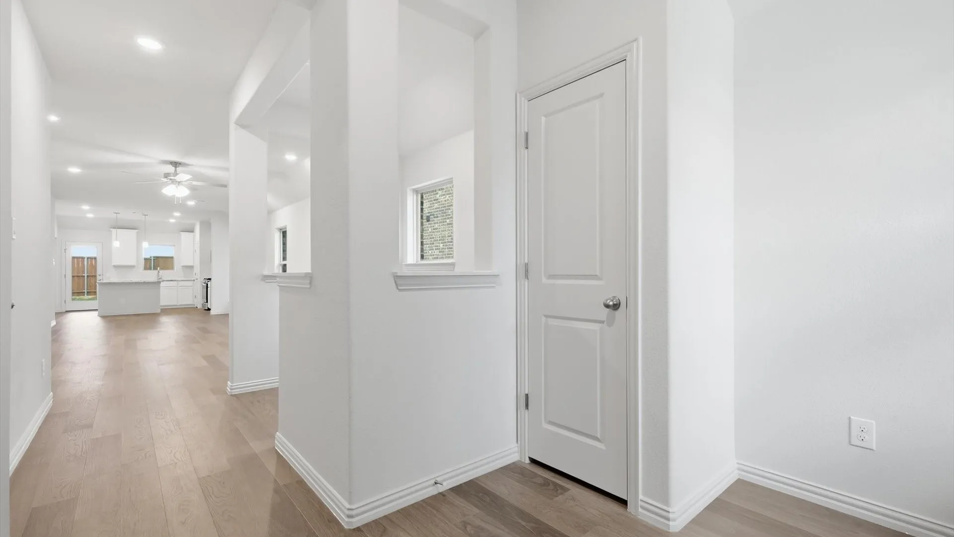 Entryway featuring wood-finish flooring, white trim, and a paneled interior door