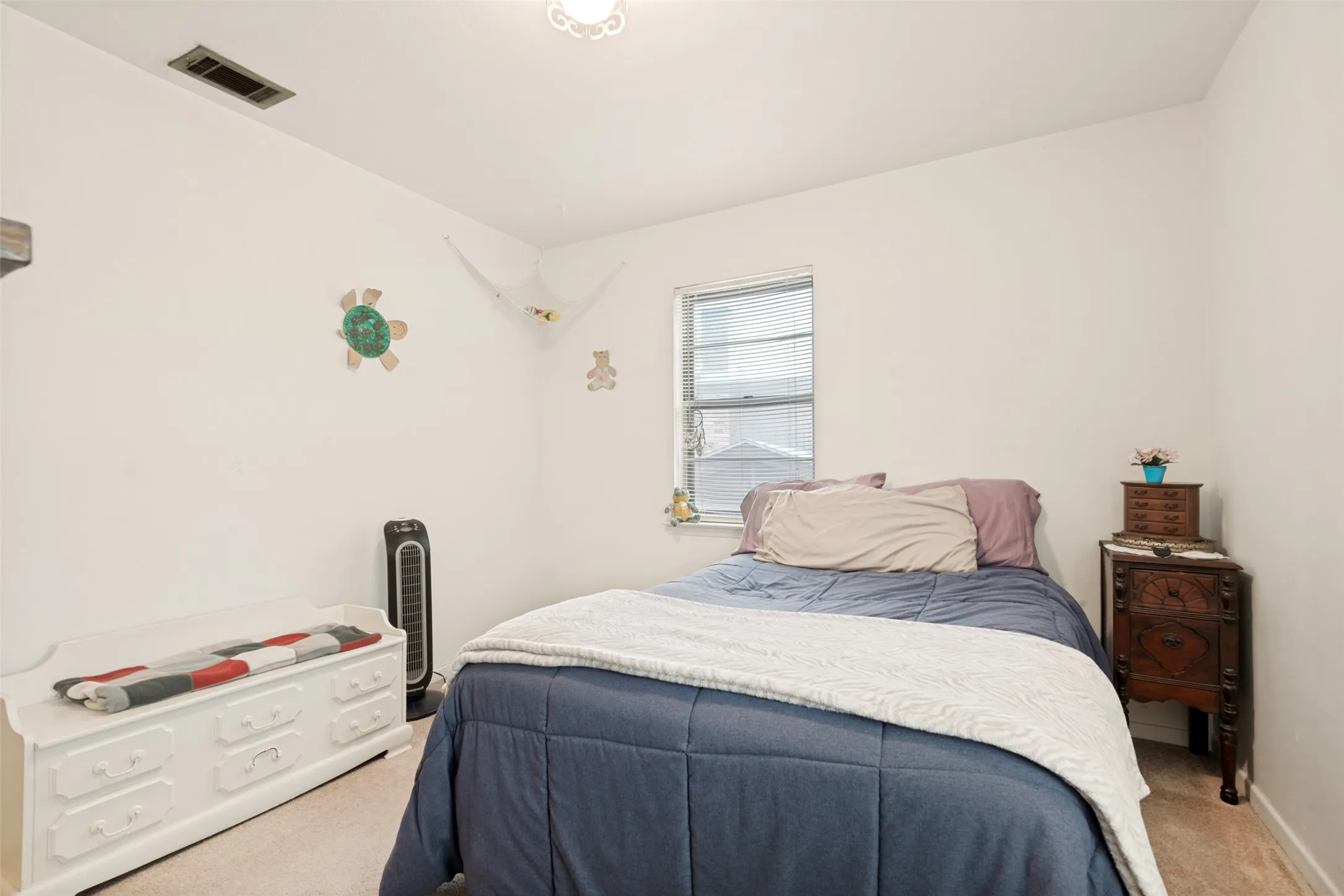 Carpeted room featuring a window with blinds, white walls, and a ceiling light fixture