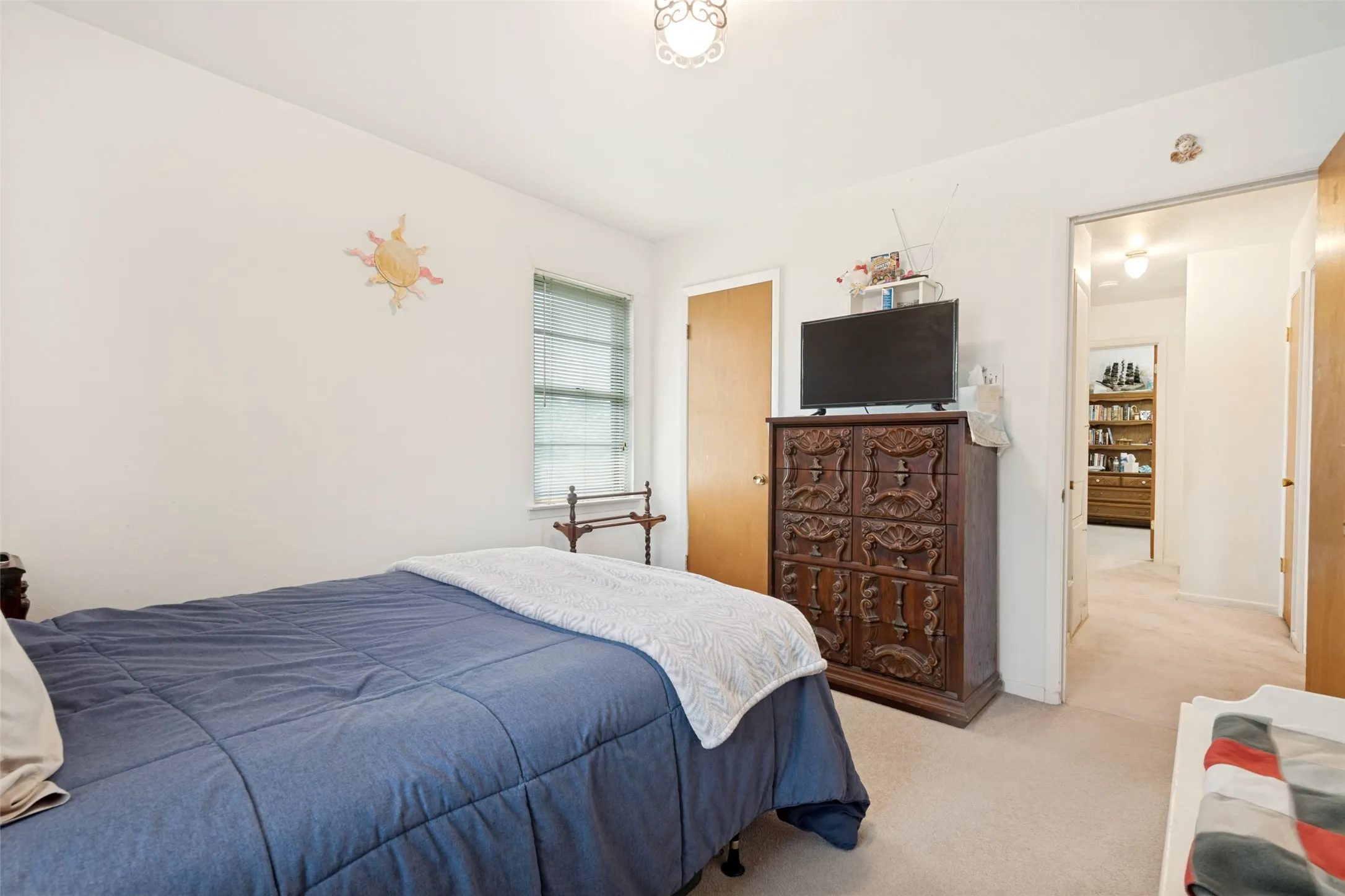 Bedroom featuring neutral wall paint, carpet flooring, a window with horizontal blinds, and a ceiling-mounted light fixture