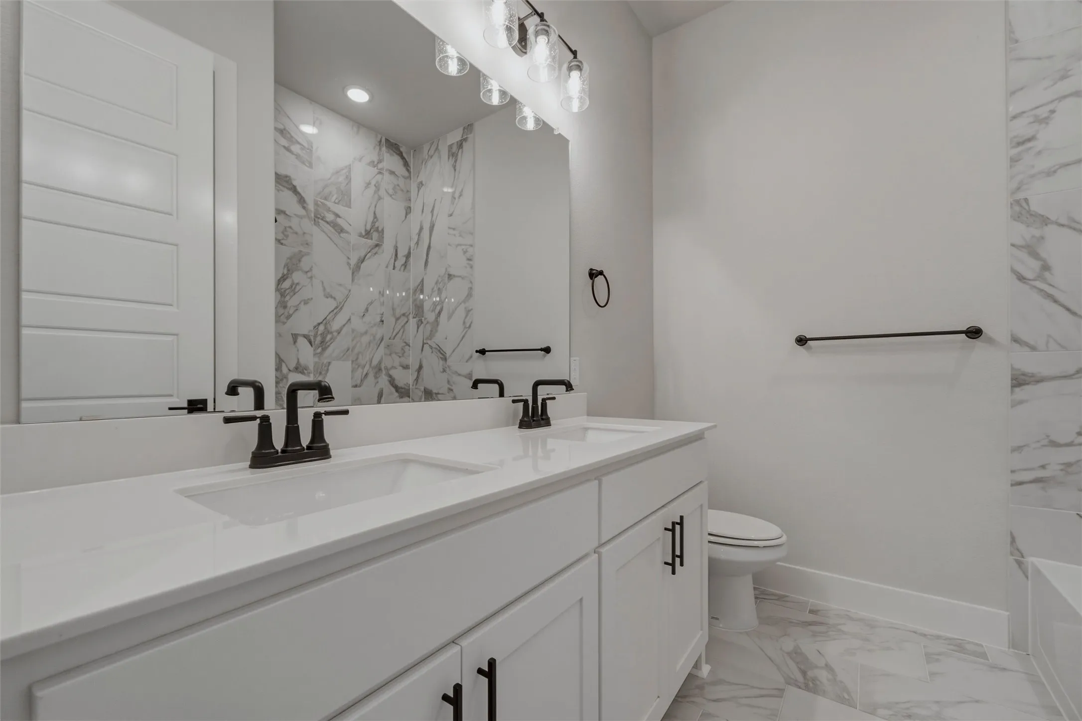 Dual vanity with integrated sinks, matte black fixtures, and white cabinetry