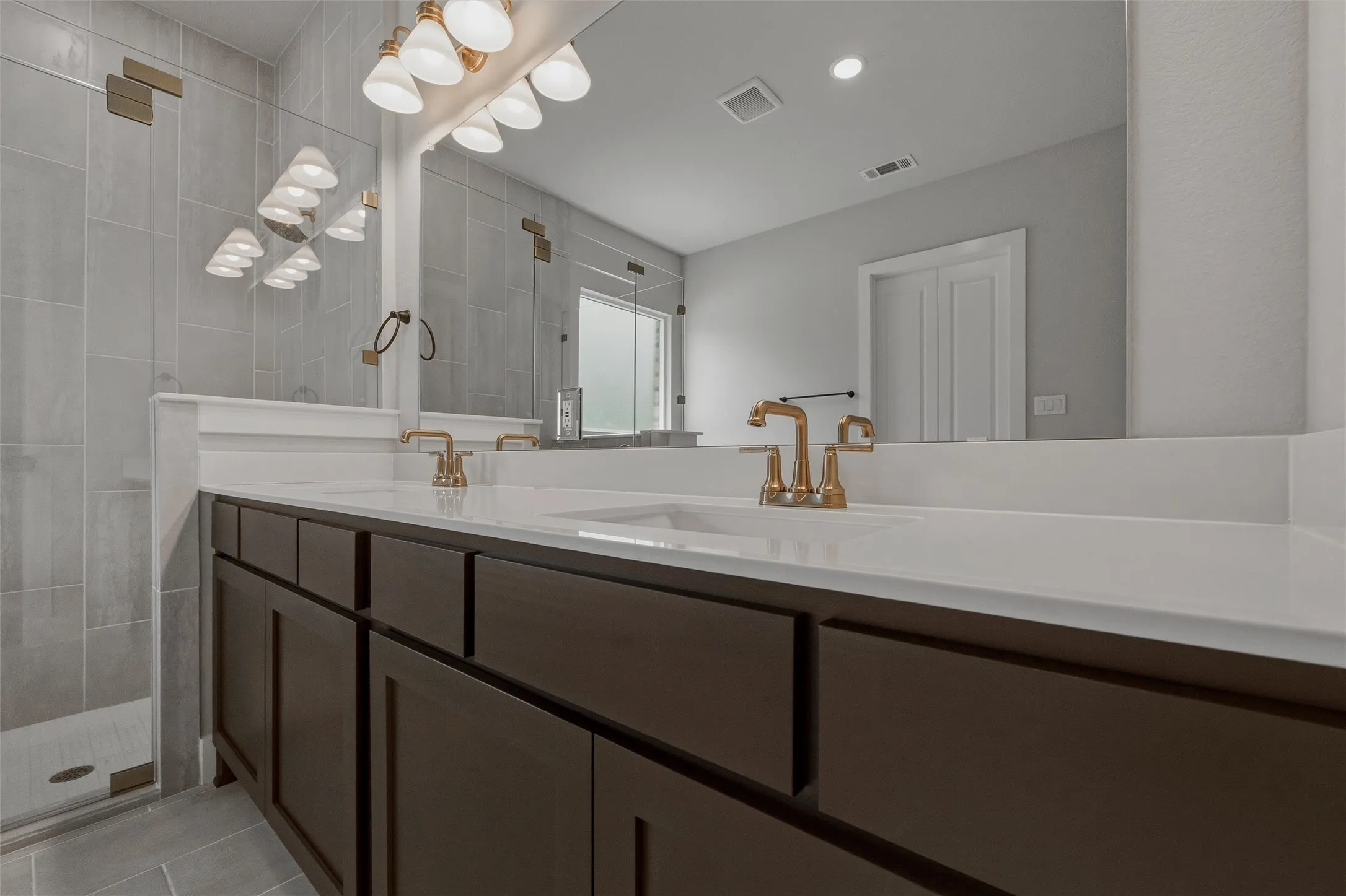 Dual vanity with undermount sinks, bronze finish faucets, and white countertops