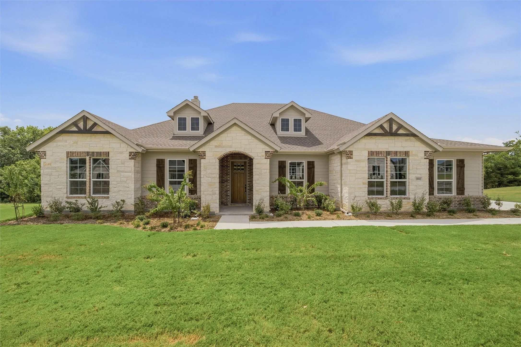 Stone and siding exterior with dark wood shutters and gable detailing