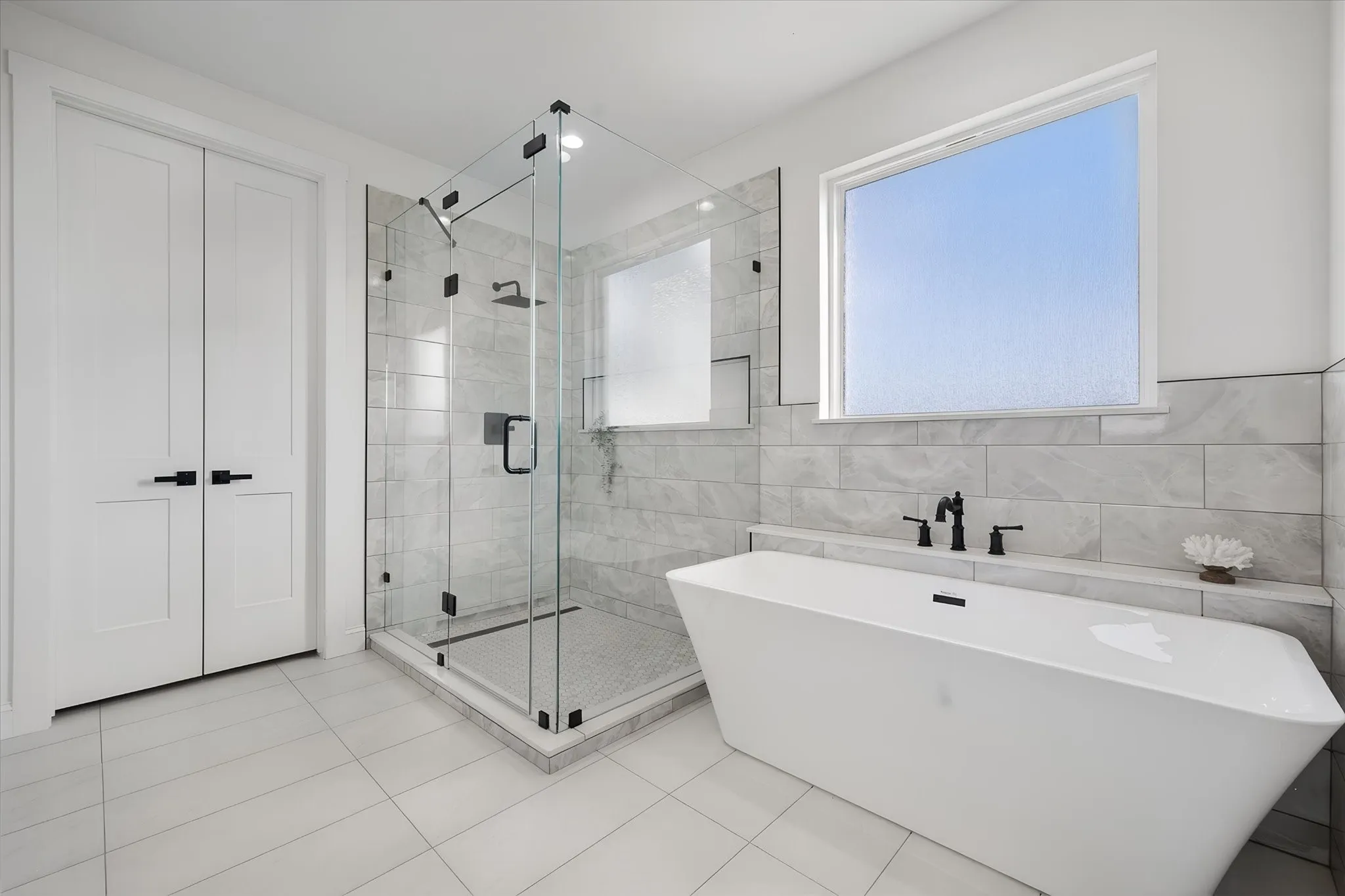 Freestanding soaking tub creates a relaxing focal point in the beautifully finished primary bathroom.