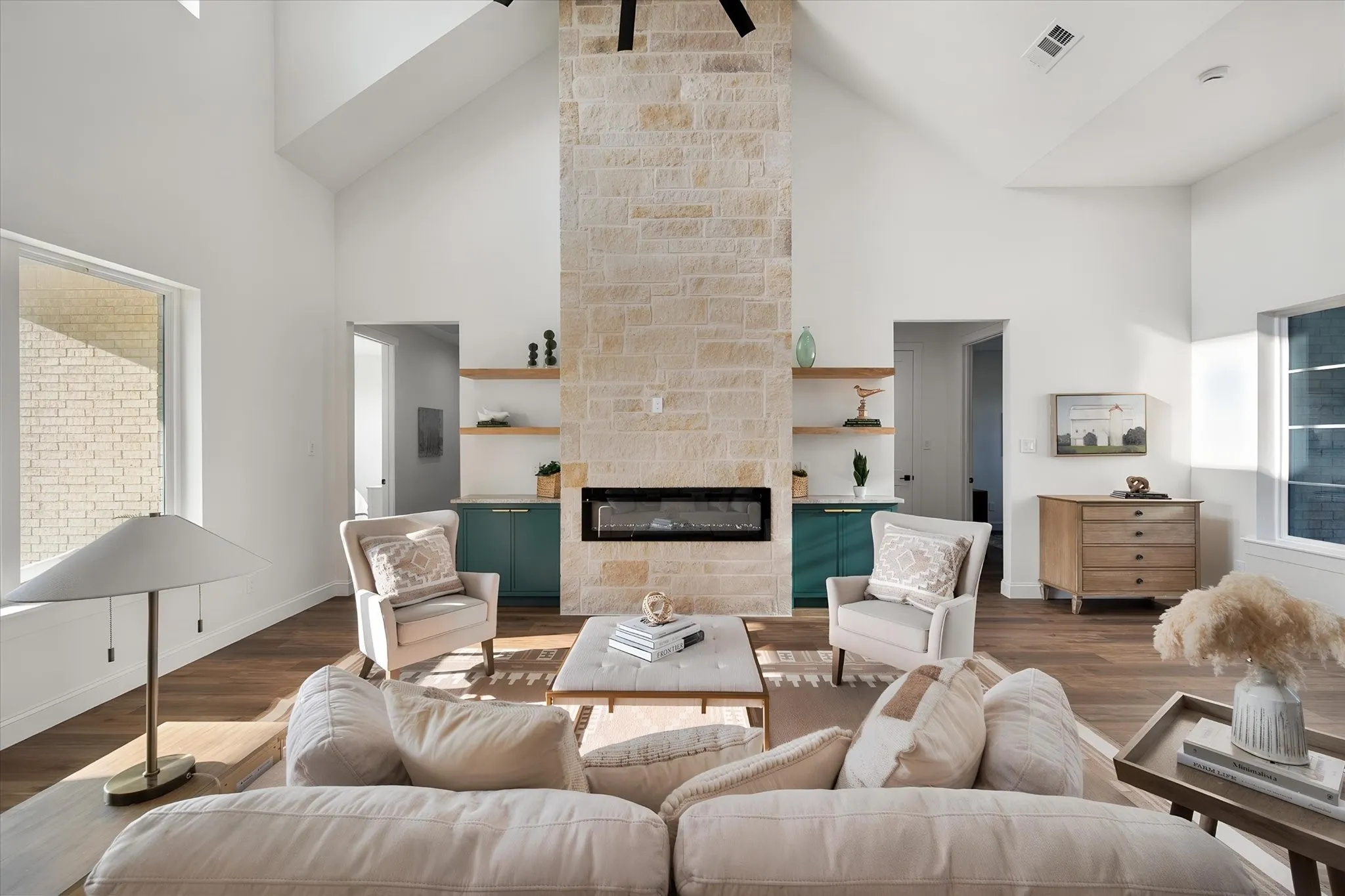 Spacious living area showcases vaulted ceilings, modern styling, and a statement fireplace.

