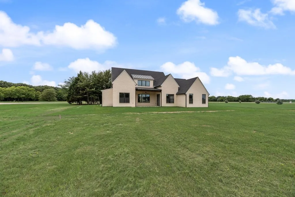 Wide backyard view showcases the home's spacious one-acre setting in The Shores community.