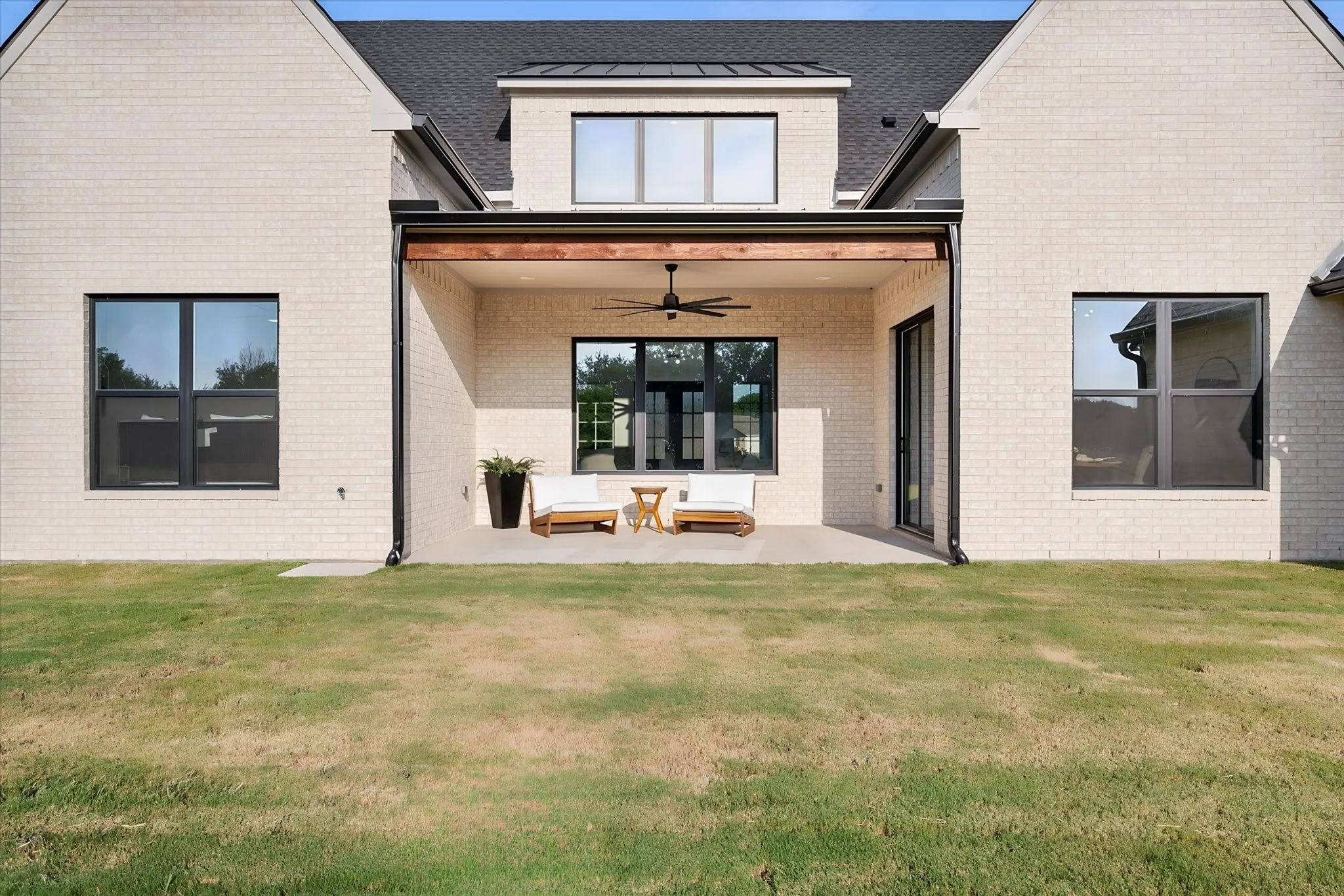 Covered rear patio overlooks the expansive backyard and provides a relaxing outdoor living space.