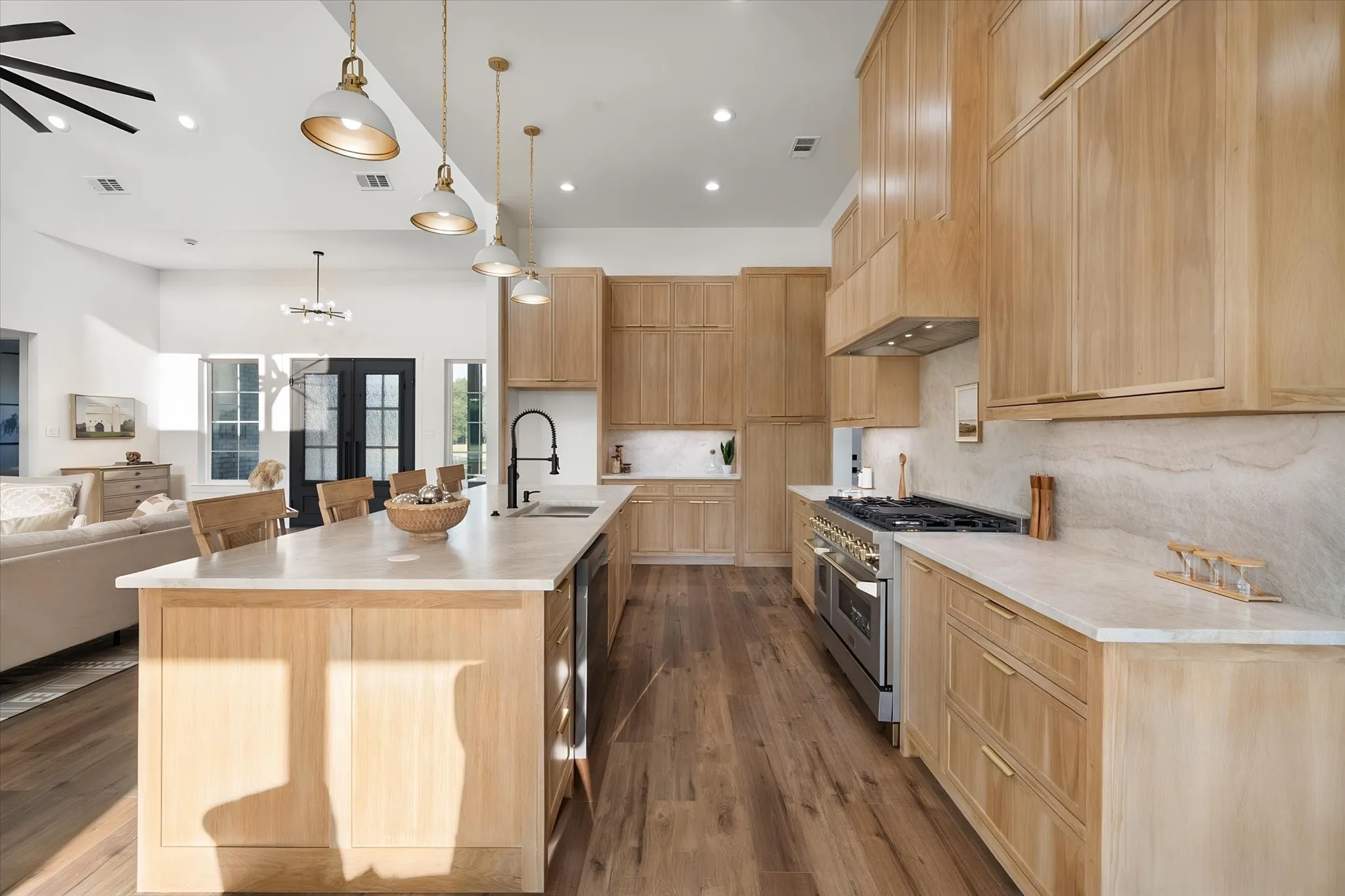 Large center island overlooks the open living area beneath soaring vaulted ceilings.
