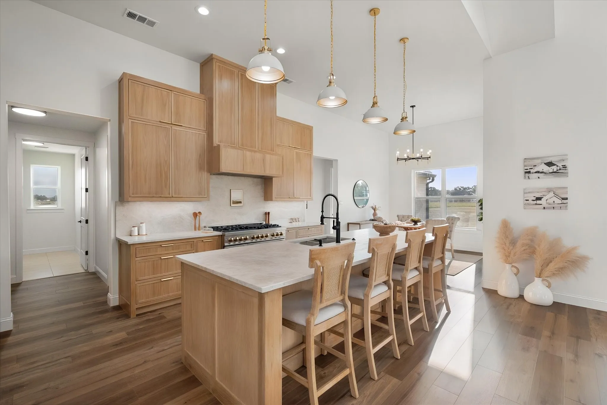 Custom cabinetry, statement lighting, and a spacious island highlight this modern farmhouse kitchen.