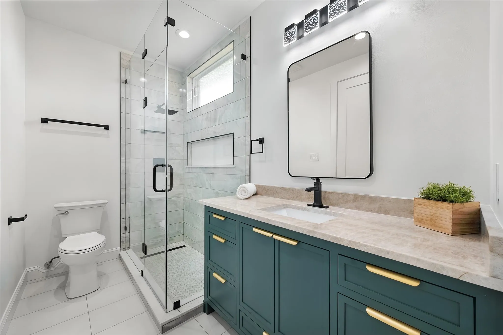 Full guest bath includes a tiled glass shower, stylish vanity, and modern black fixtures.