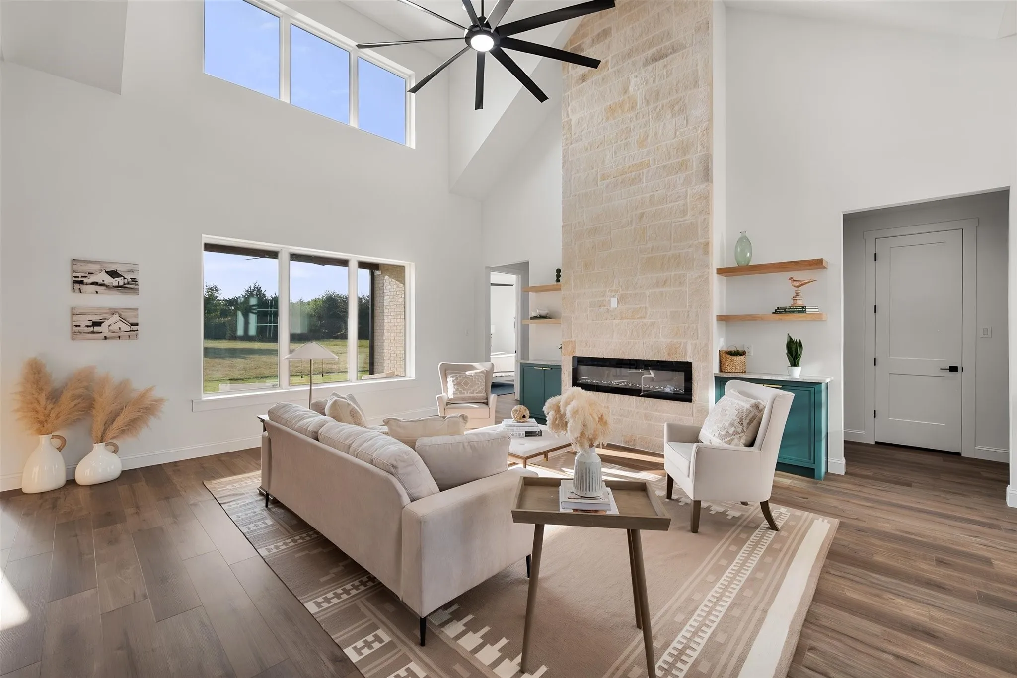 Light-filled living room centered around a dramatic floor-to-ceiling fireplace with built-in shelving.