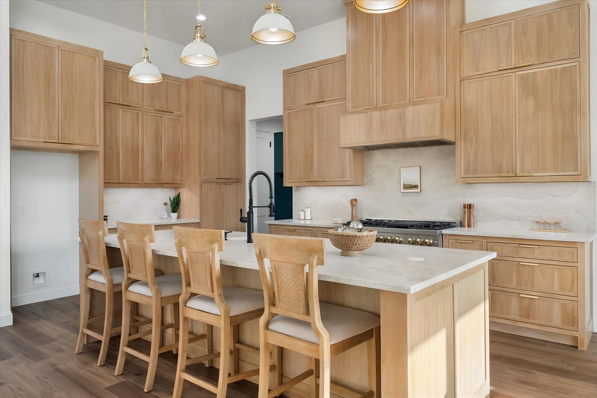 Sleek modern farmhouse kitchen combines quartzite surfaces, custom cabinetry, and generous seating.