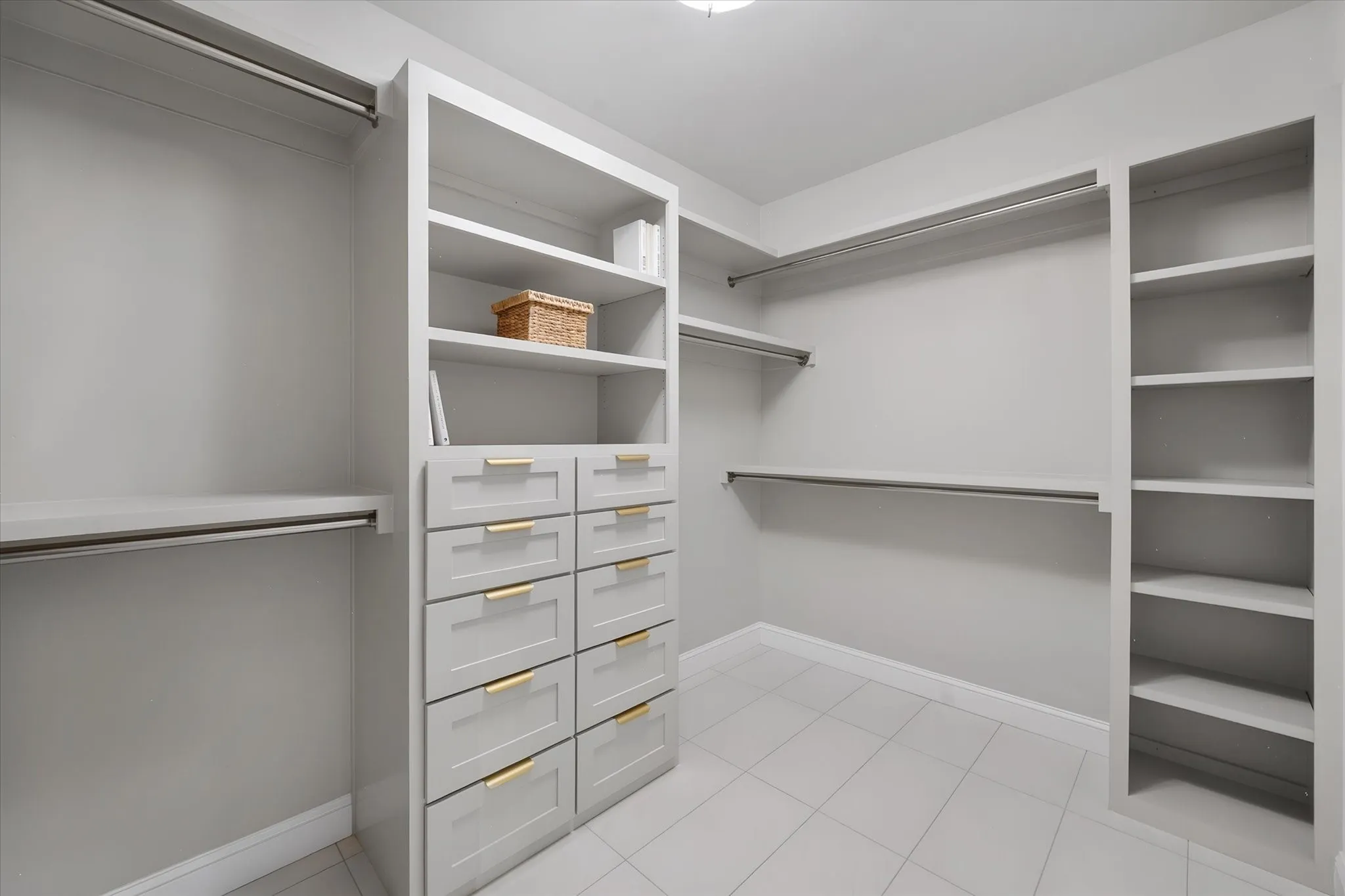 Custom primary closet system offers built-in shelving, drawers, and plentiful hanging space.