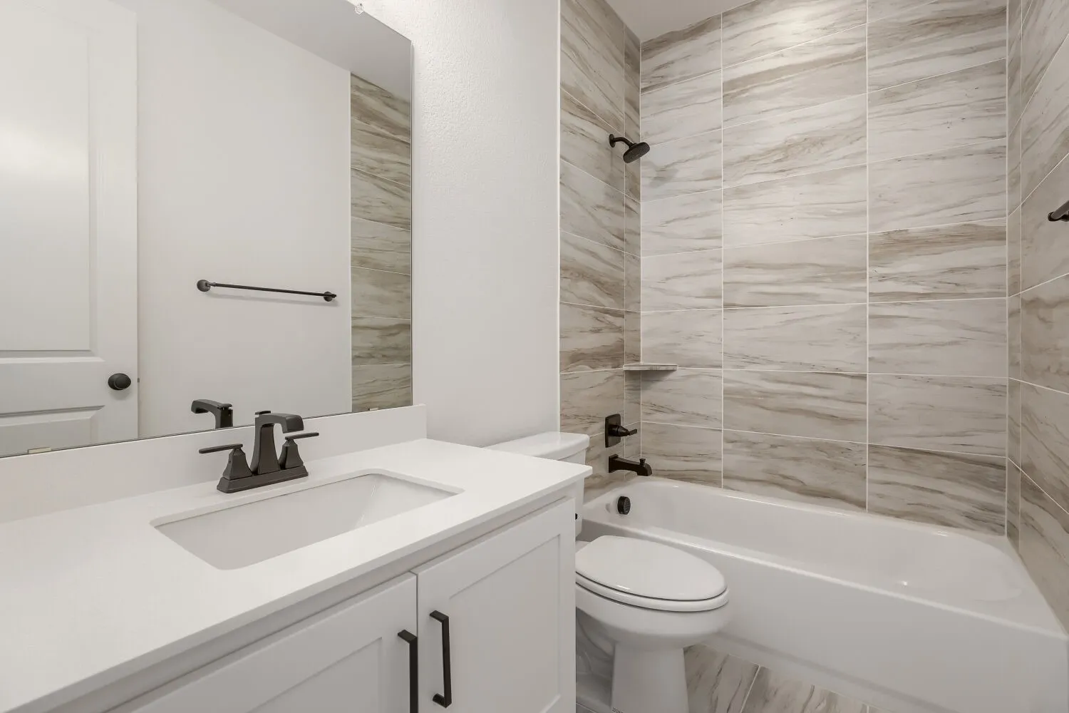White vanity with a rectangular undermount sink, a white countertop, and a matte black faucet
