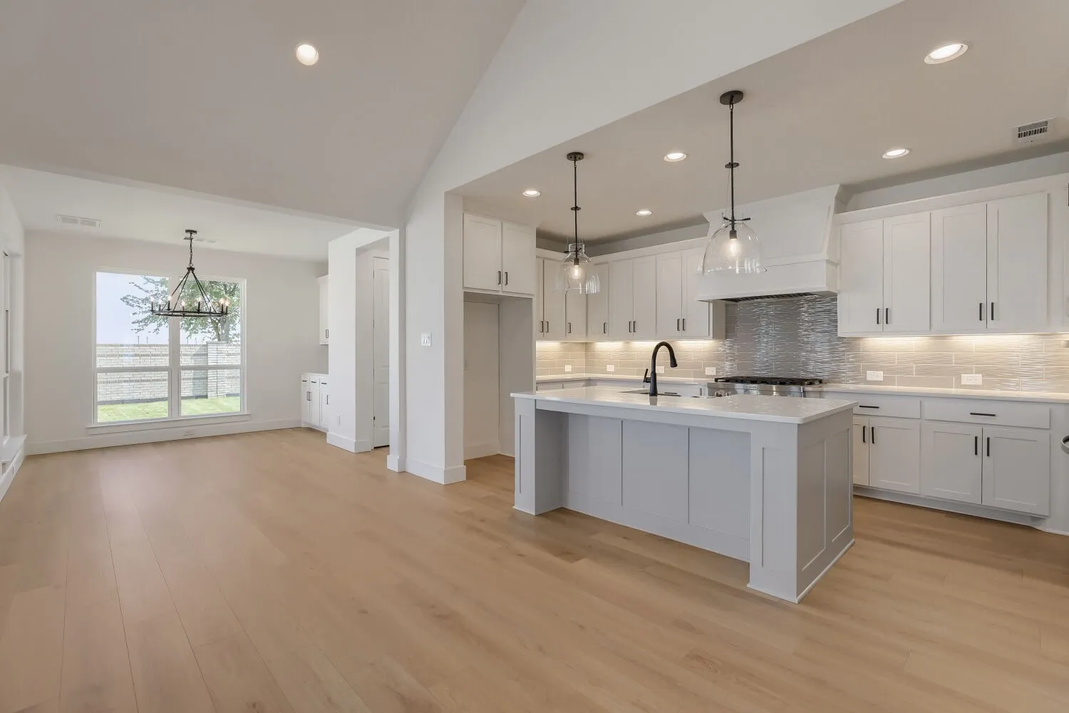 Spacious kitchen and dining area featuring light wood-finish flooring
