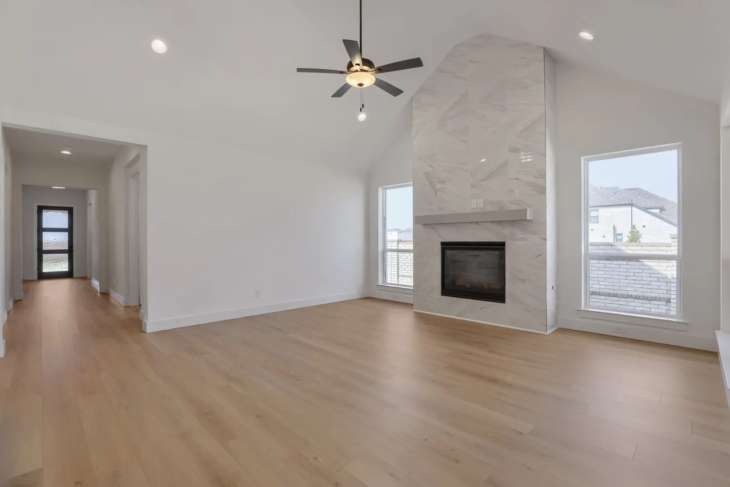 Living area featuring vaulted ceilings, wood-finish flooring, and recessed lighting