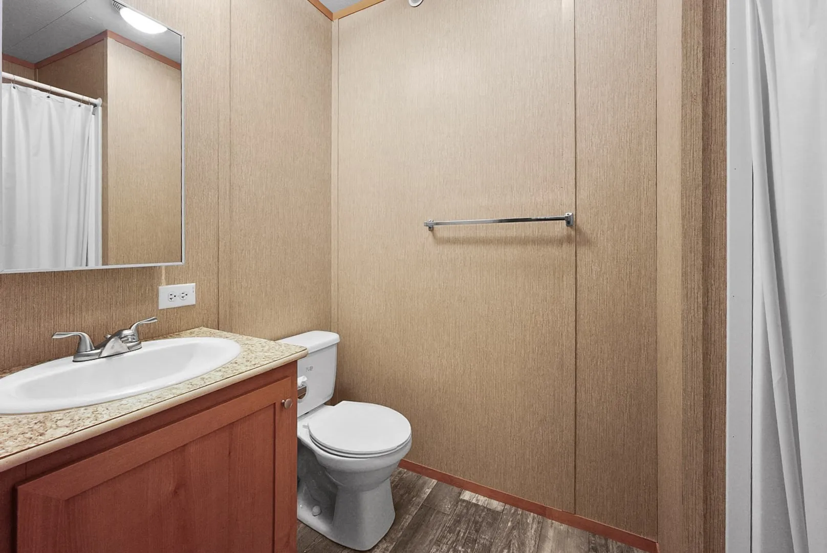 Bathroom with wood-finish flooring and panel walls