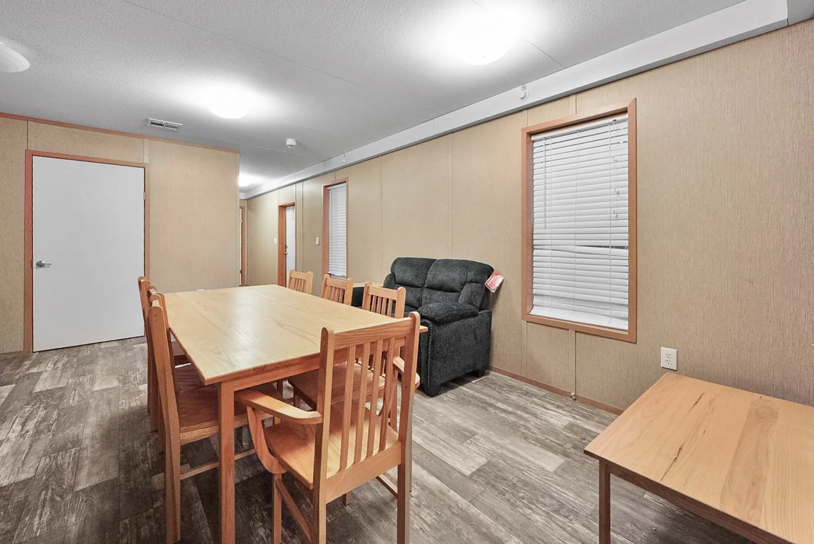 Spacious dining area featuring wood-finish flooring and panel accent walls