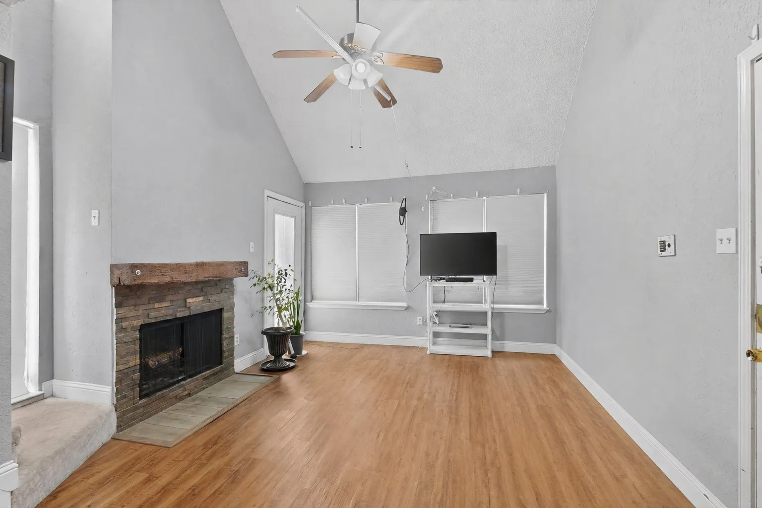 Living area featuring a vaulted ceiling and wood-finish flooring