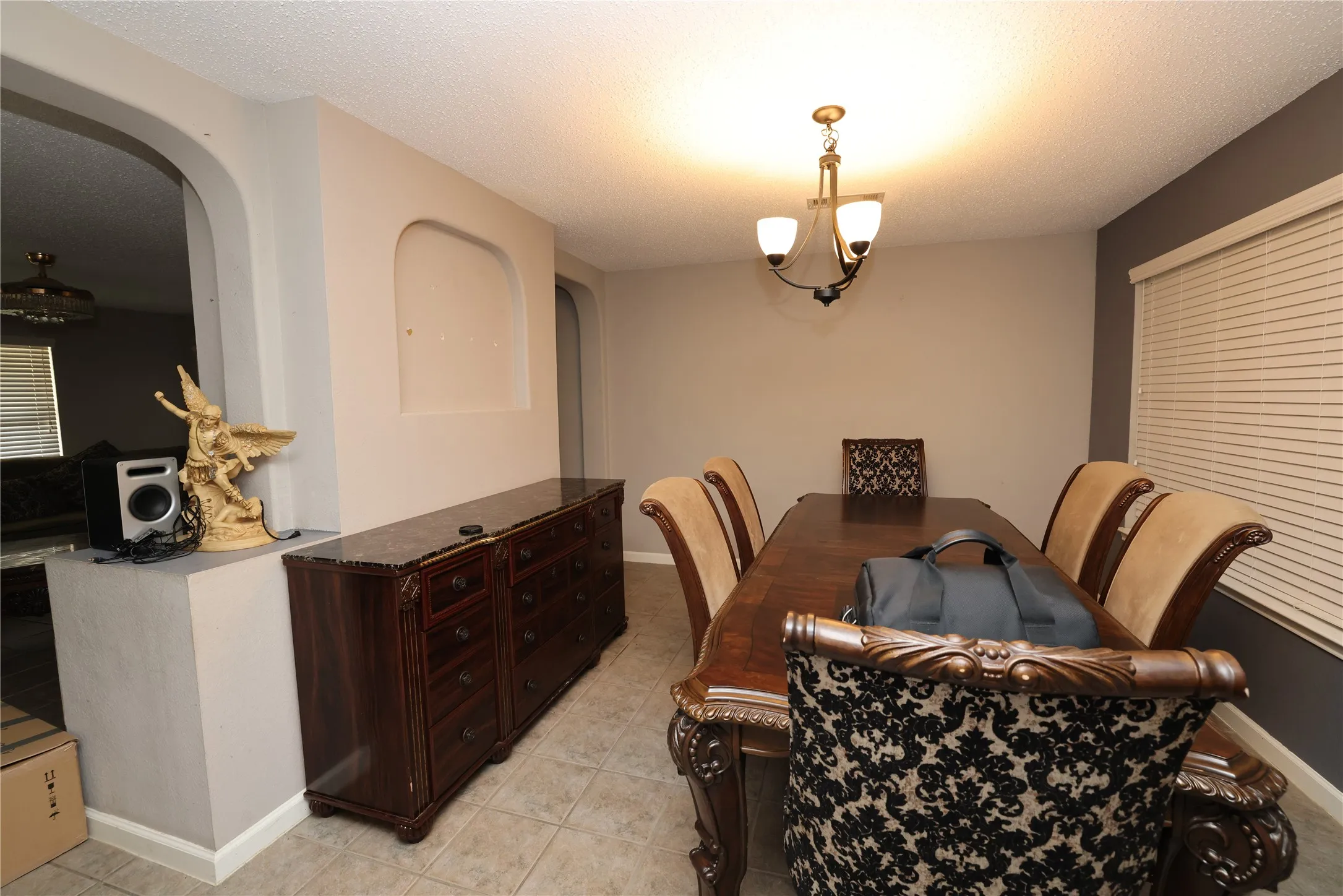 Dining area with tile flooring and a chandelier light fixture