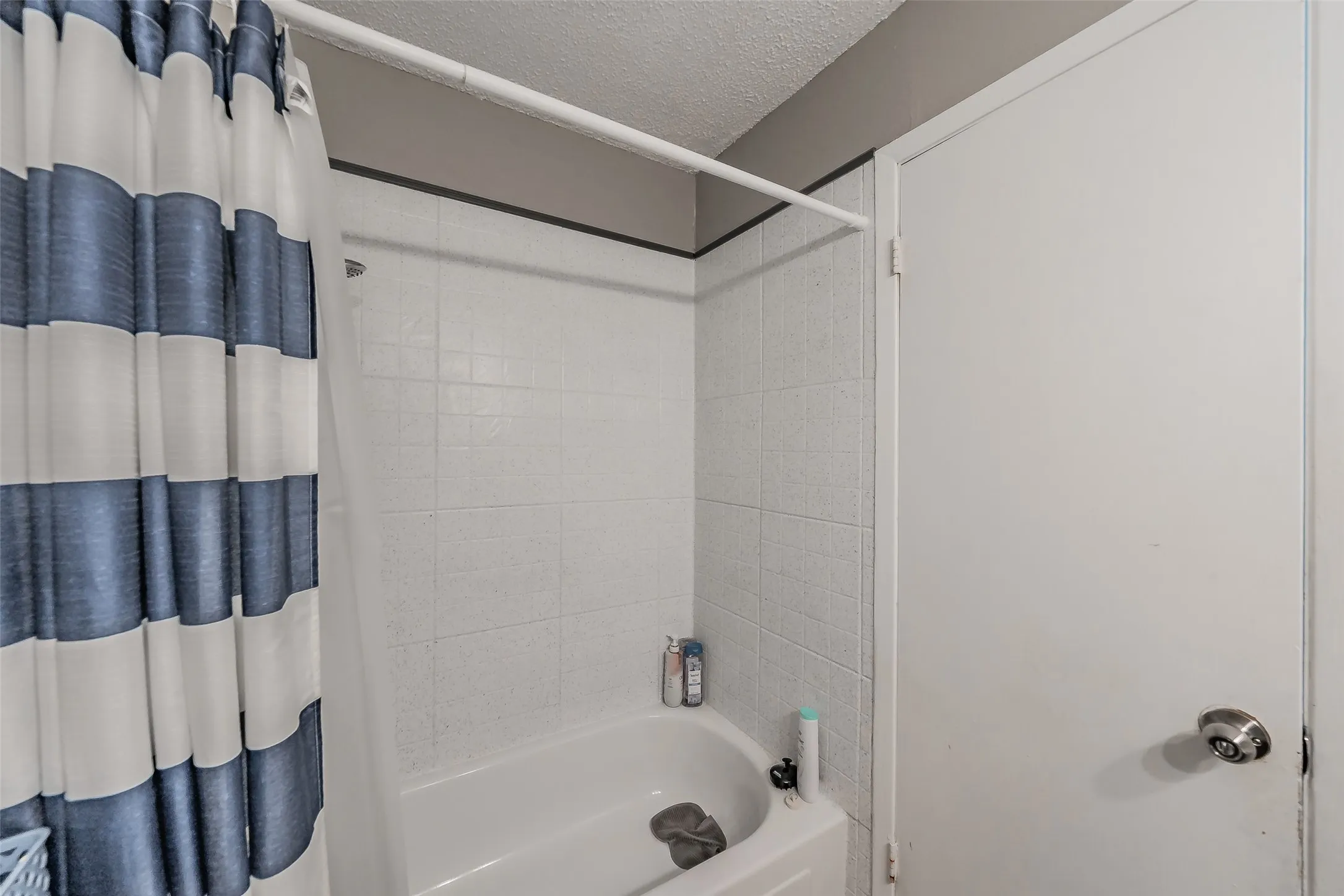 Ceramic tiled bathtub in guest bathroom.