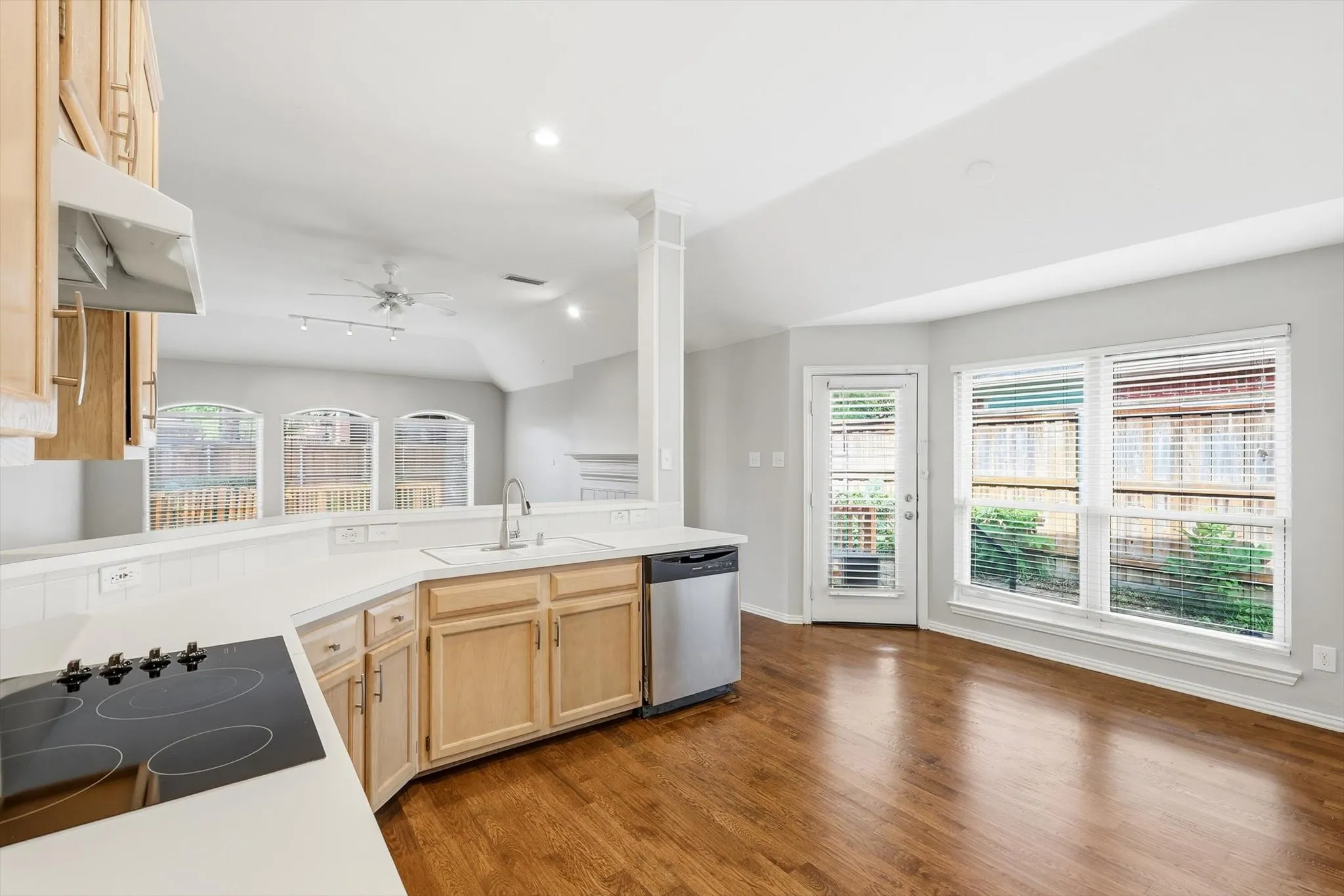 Kitchen featuring a built-in cooktop, stainless steel dishwasher, and light wood cabinetry