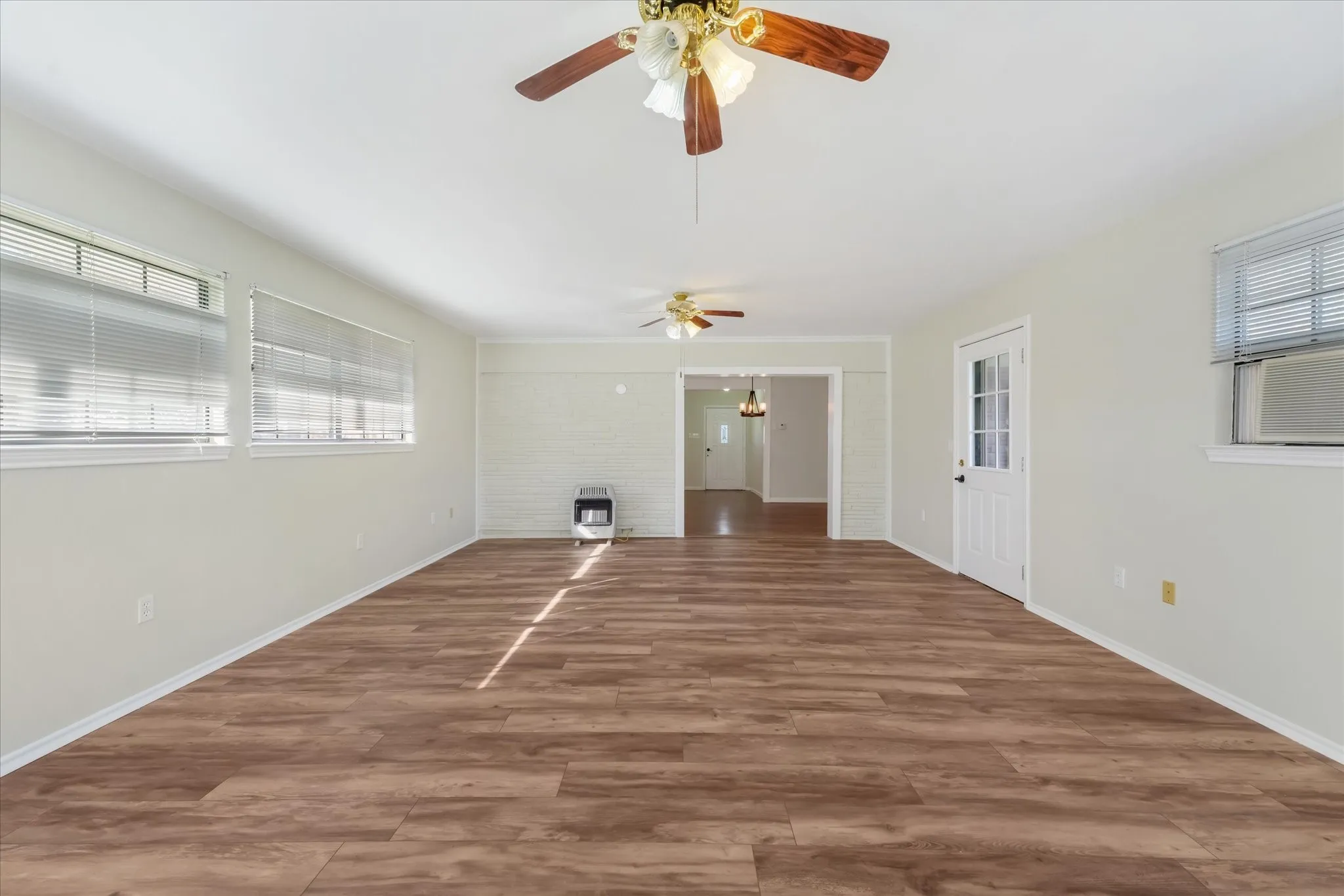 Unfurnished living room with wood finished floors, heating unit, and cooling unit