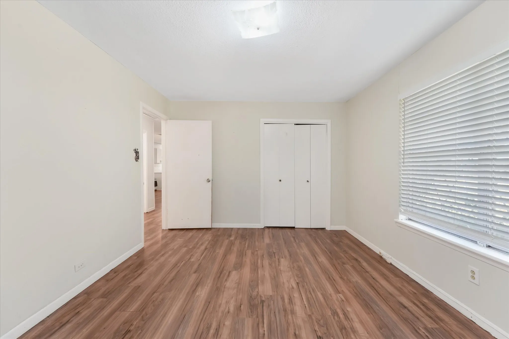 Unfurnished bedroom featuring wood finished floors and a closet
