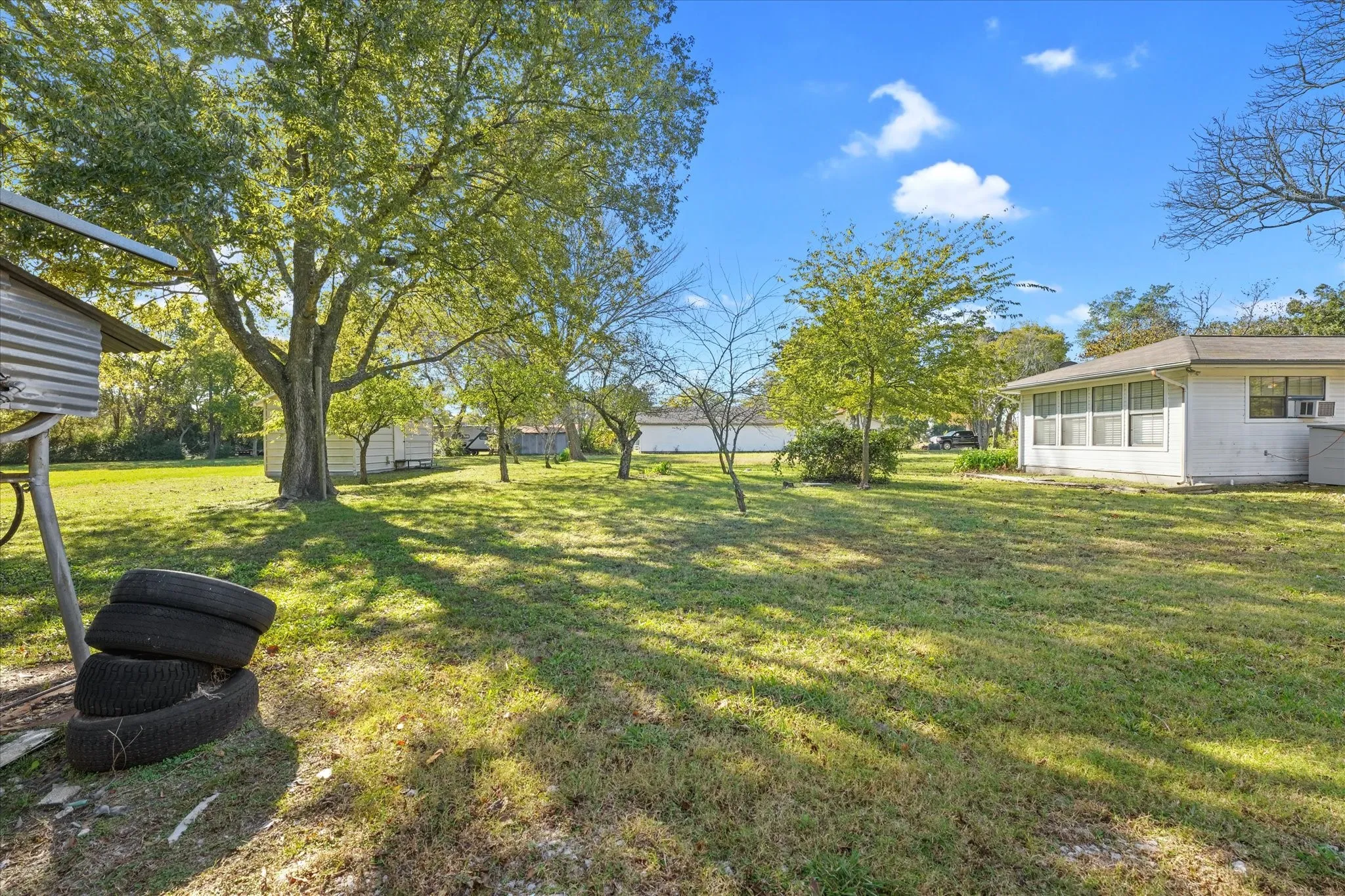 View of grassy yard with a sunroom