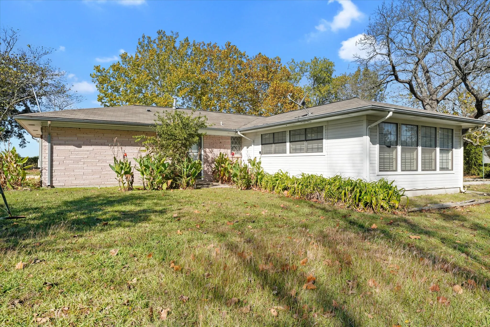 Single story home with a front lawn and brick siding