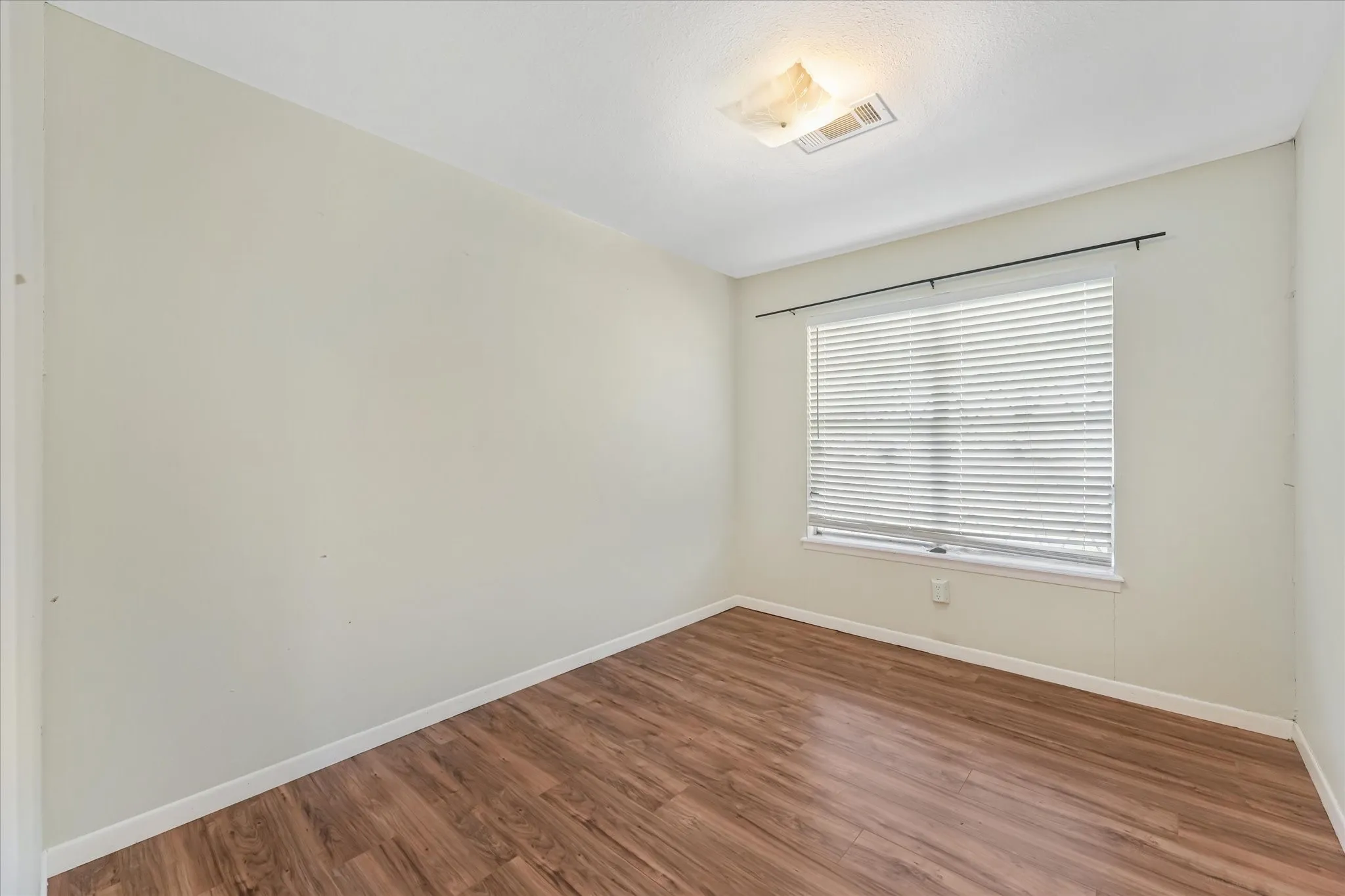 Unfurnished room with wood finished floors and baseboards