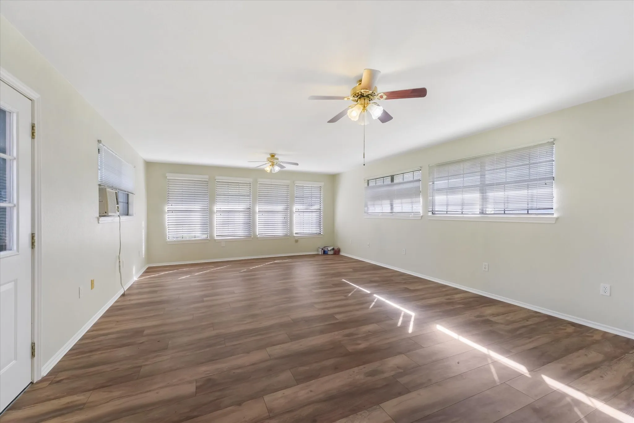 Empty room featuring dark wood finished floors and ceiling fan