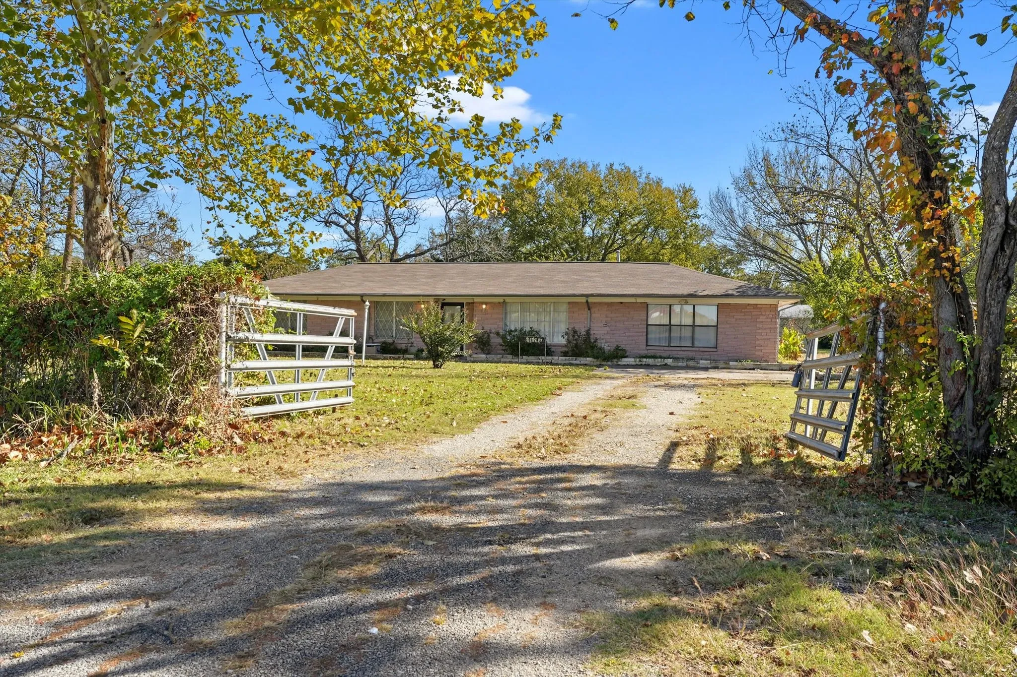 Ranch-style home with brick siding and dirt driveway