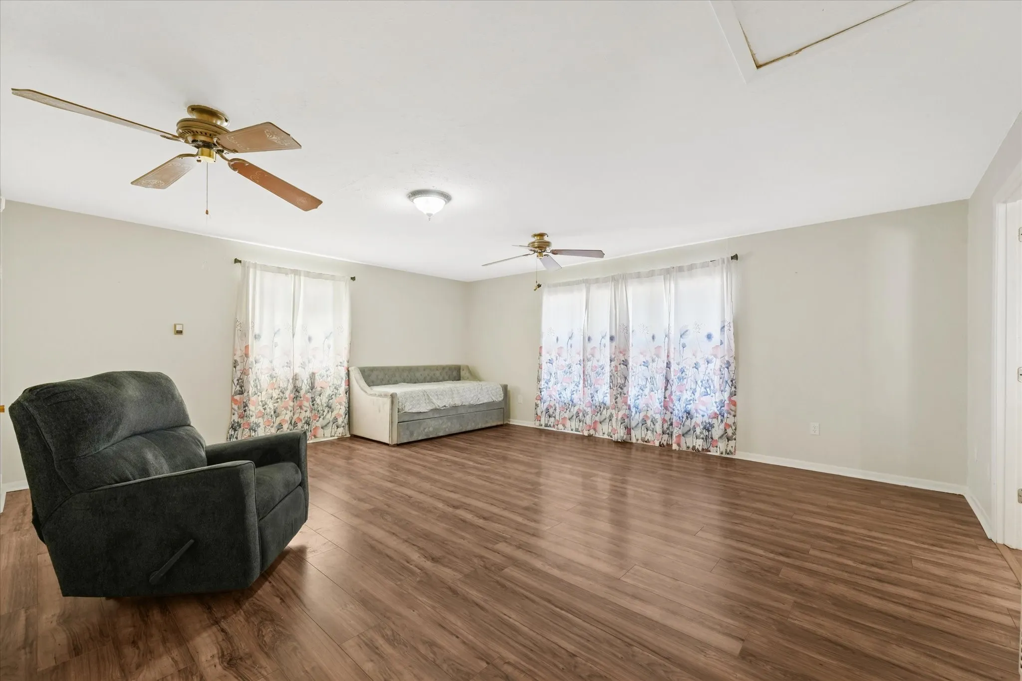 Sitting room featuring dark wood finished floors, healthy amount of natural light, and ceiling fan