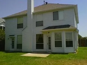 Two-story residential structure with white siding and a shingle roof