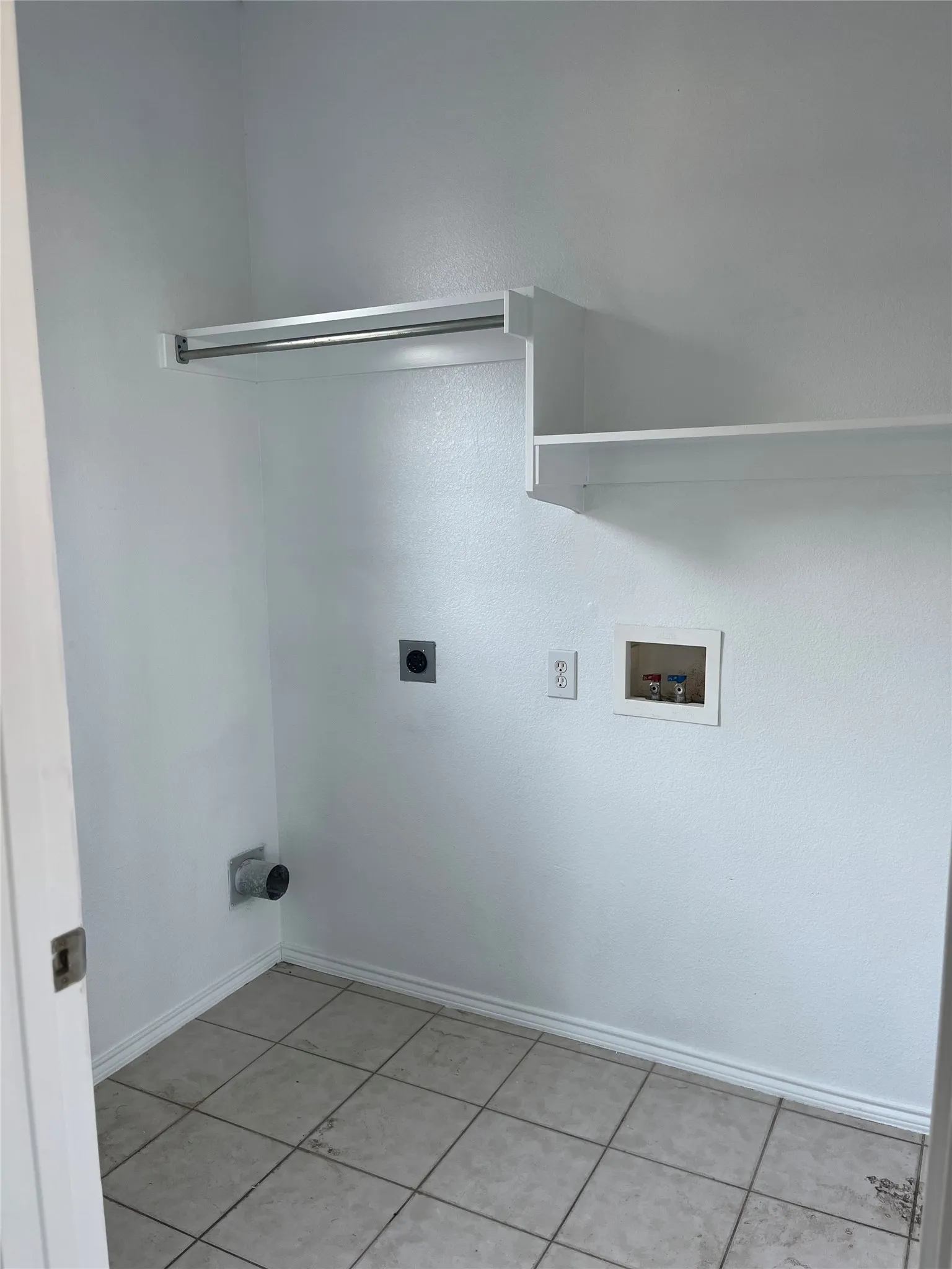 Utility room featuring neutral wall finishes and tiled flooring