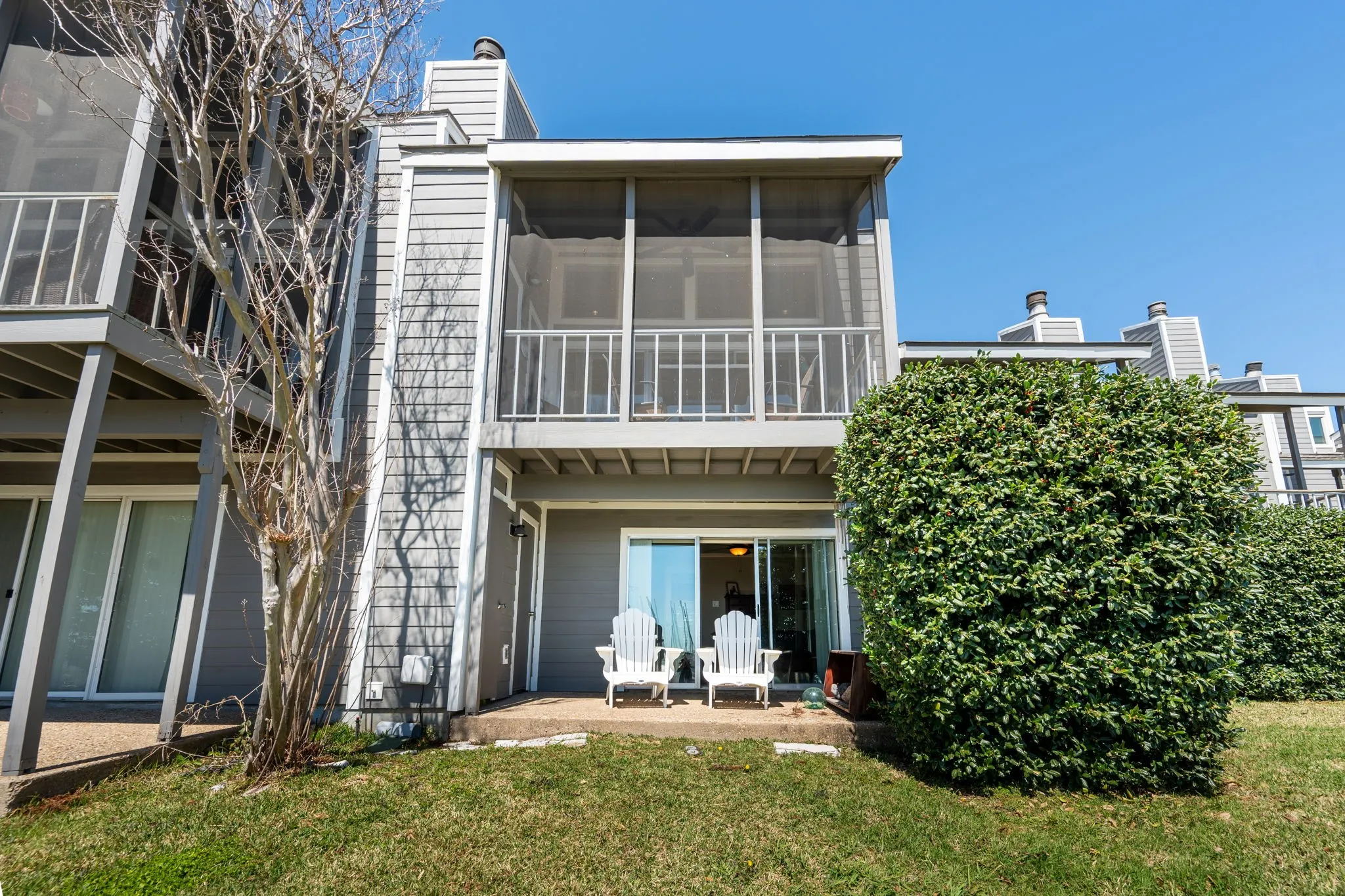 Screened balcony with white railing facing the water