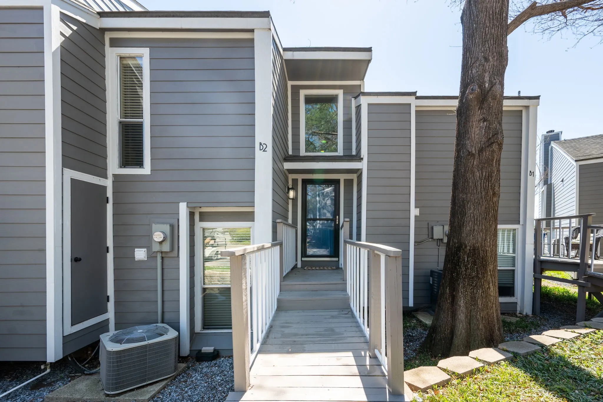 Contemporary townhome exterior featuring gray siding with white trim