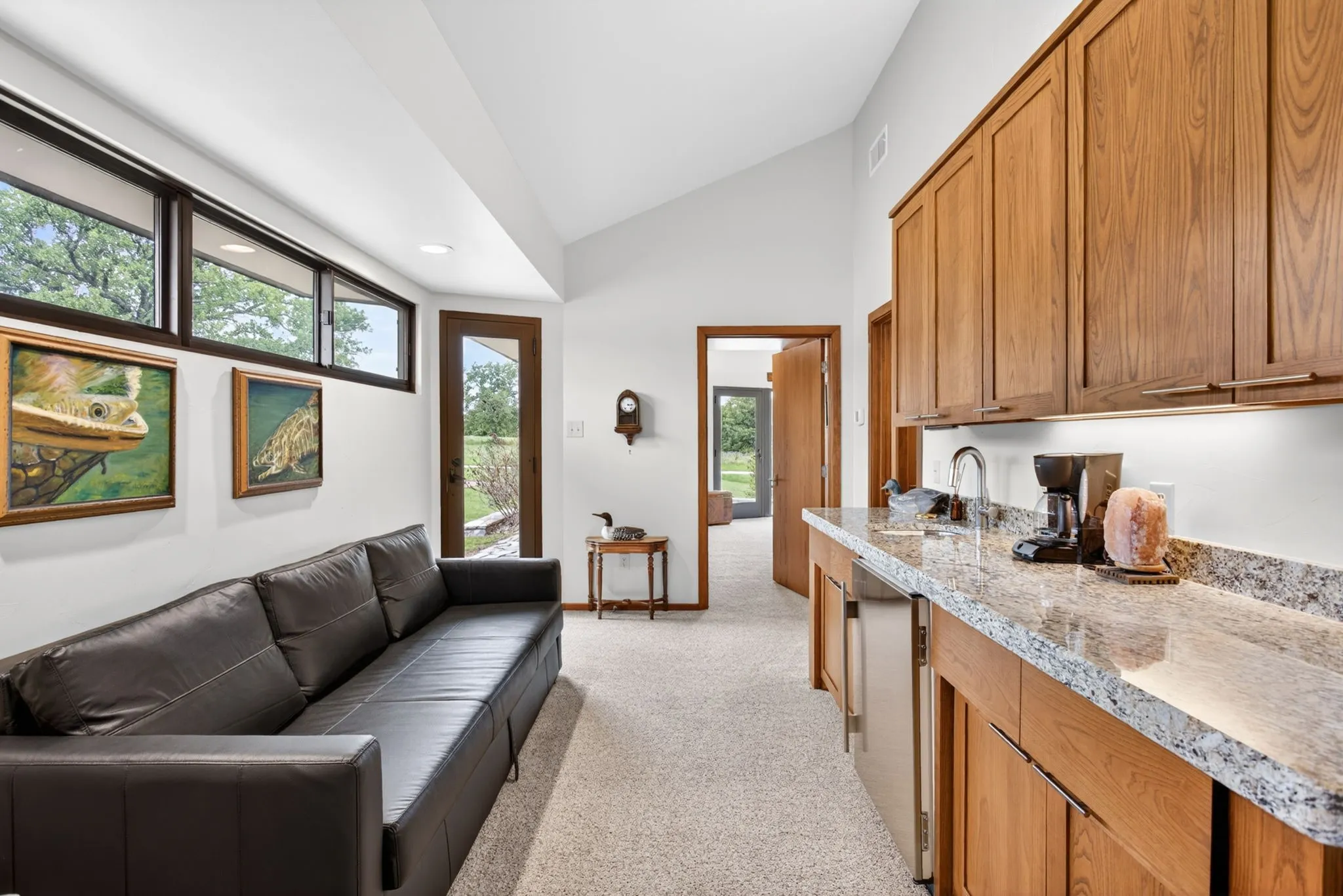 Wet bar with granite-style countertops, wood cabinetry, and stainless steel under-counter refrigerator