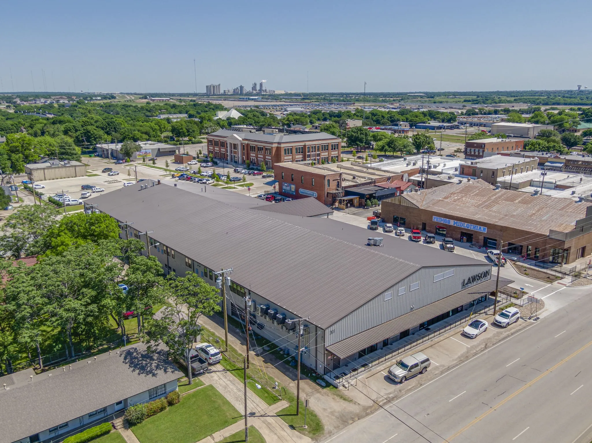 Expansive commercial property featuring a metal roof and light-colored siding