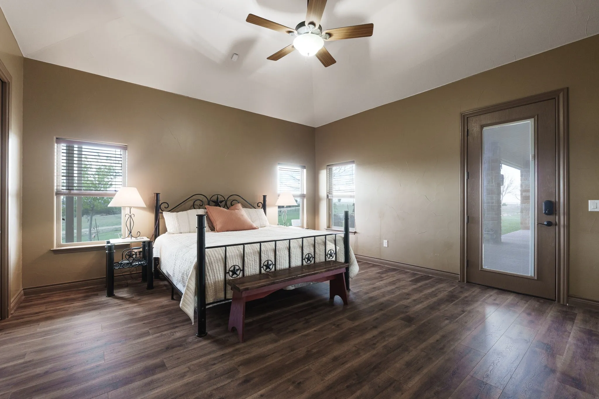 Spacious room featuring wood-finish flooring, vaulted ceilings, and a ceiling fan
