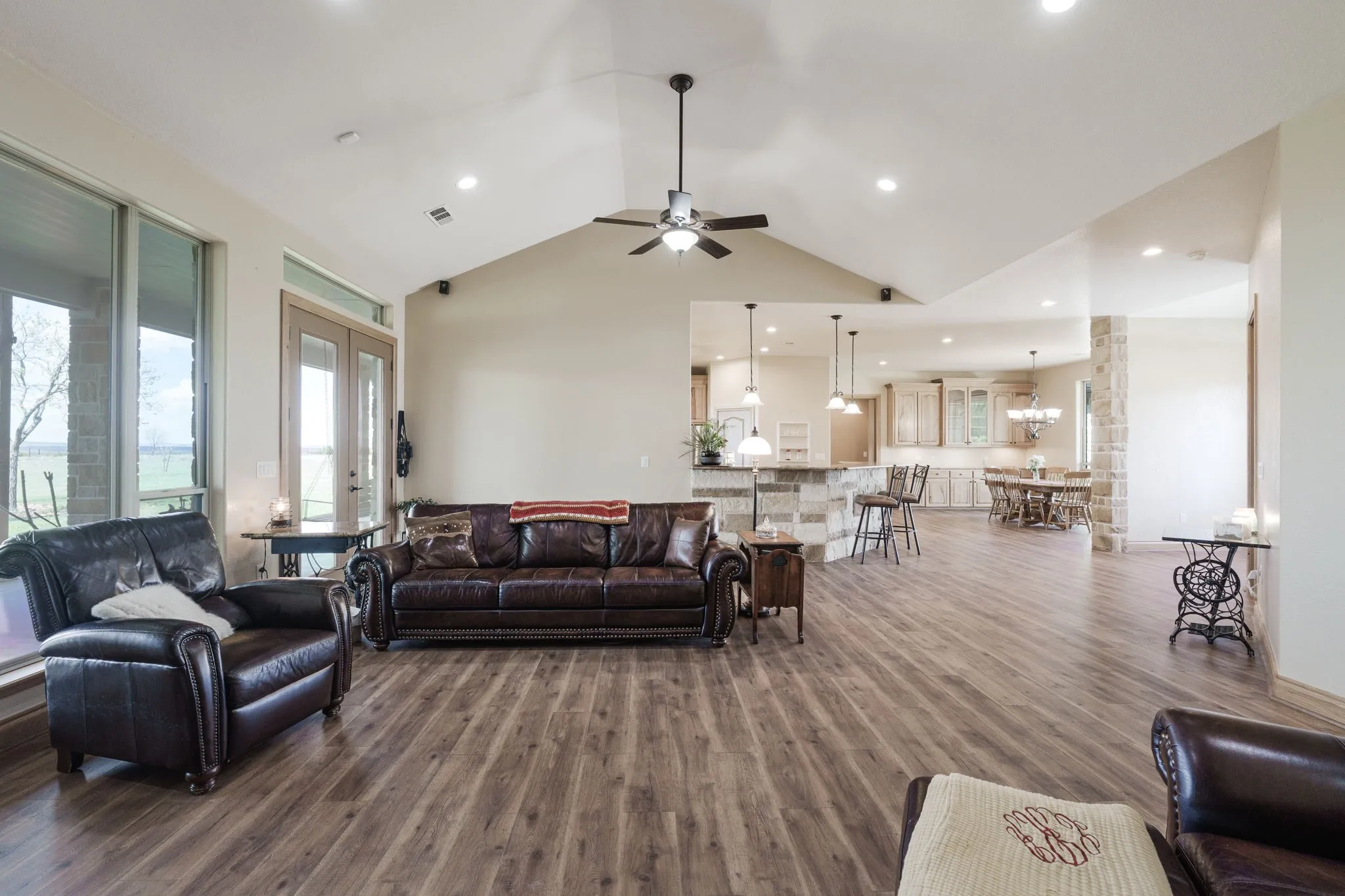 Spacious living area featuring vaulted ceilings, recessed lighting, and wood-finish flooring