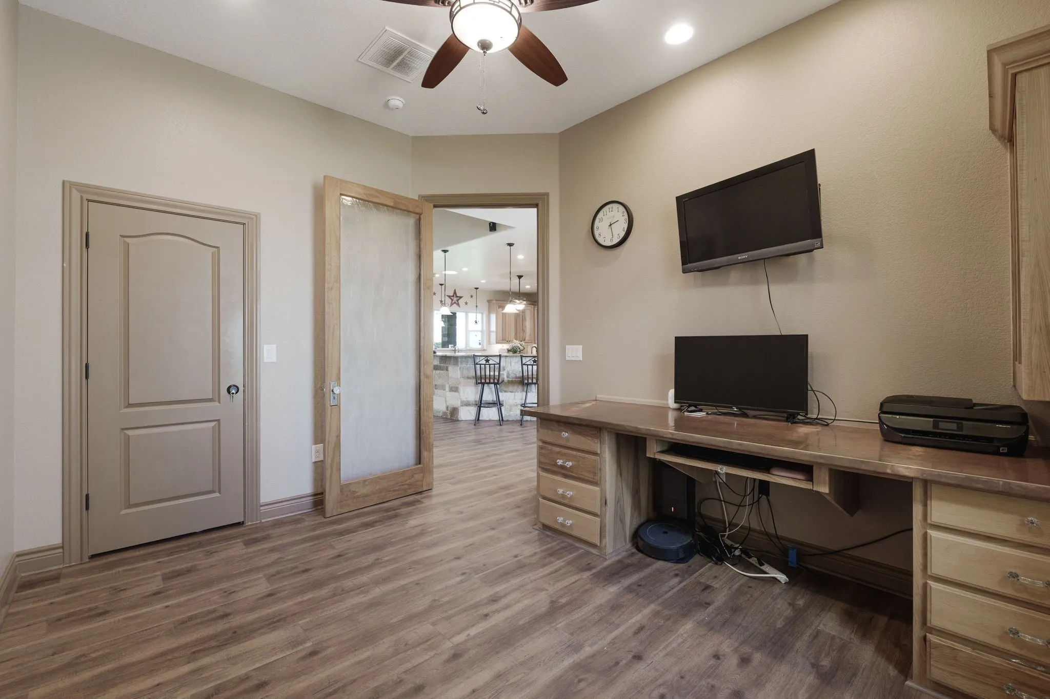Room with wood-finish flooring and a ceiling fan