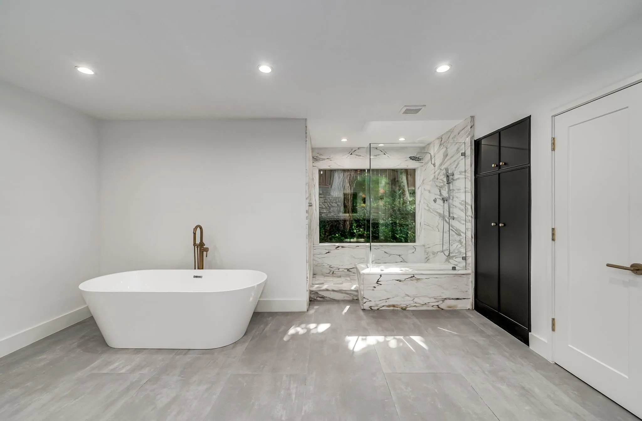 Full bathroom featuring a freestanding bath, recessed lighting, and a marble finish shower