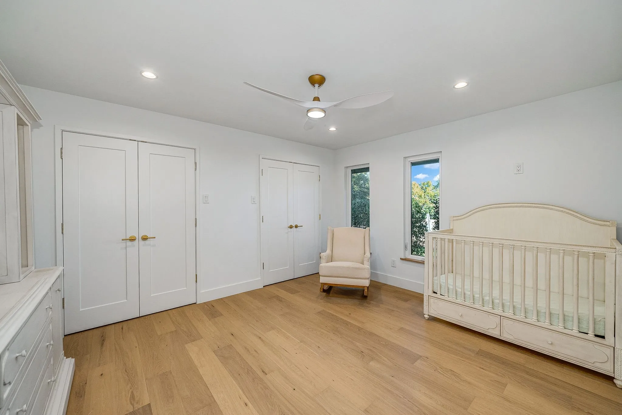 Bedroom with multiple closets, light wood-style flooring, recessed lighting, ceiling fan, and a nursery area